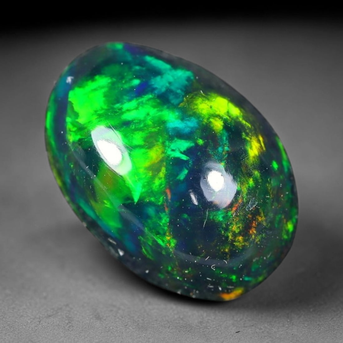2.44ct Natural Ethiopian Welo Black Smoked Opal Cabochon Loose Gemstone, 6FX: This fully polished Ethiopian Welo opal features a dark smoked base with vivid, sweeping play-of-color shifting across its glossy dome surface, measured at 11x8x5mm. The black smoke treatment deepens 
