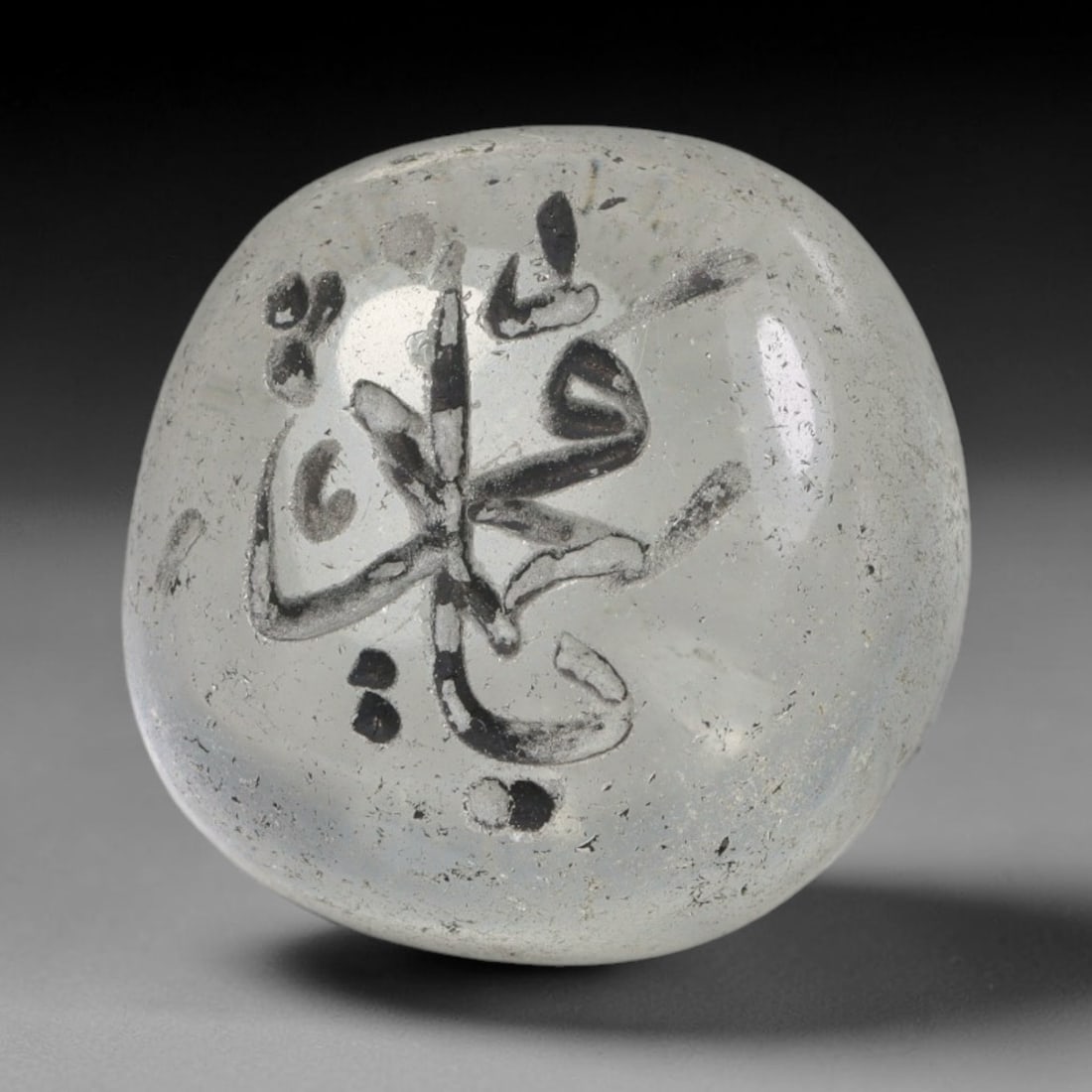 Early Vintage Islamic White Glass Calligraphic Intaglio Seal Cabochon (Post 1900 CE), 88BX: This early vintage glass intaglio seal cabochon draws from enduring Islamic seal-making traditions, formed from translucent pale glass with a smoothly rounded polished surface. The face features caref