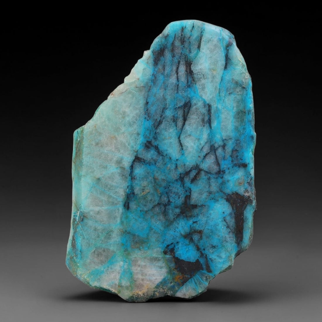 110ct Natural Peruvian Chrysocolla Polished Slab Rough, 63AR: This partial-polished chrysocolla slab features blended mineral matrix with smooth refined face and unaltered natural rugged edge across its 56x36x5mm elongated form, translucent mineral layers hold s