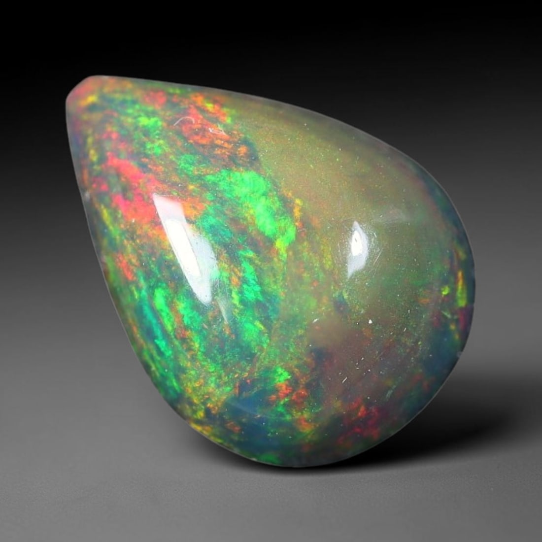 1.80ct Natural Ethiopian Welo Black Smoked Opal Cabochon Loose Gemstone, 73FX: This fully polished Ethiopian Welo opal features a dark smoked base with vivid, sweeping play-of-color shifting across its glossy dome surface, measured at 11x8x4mm. The black smoke treatment deepens 