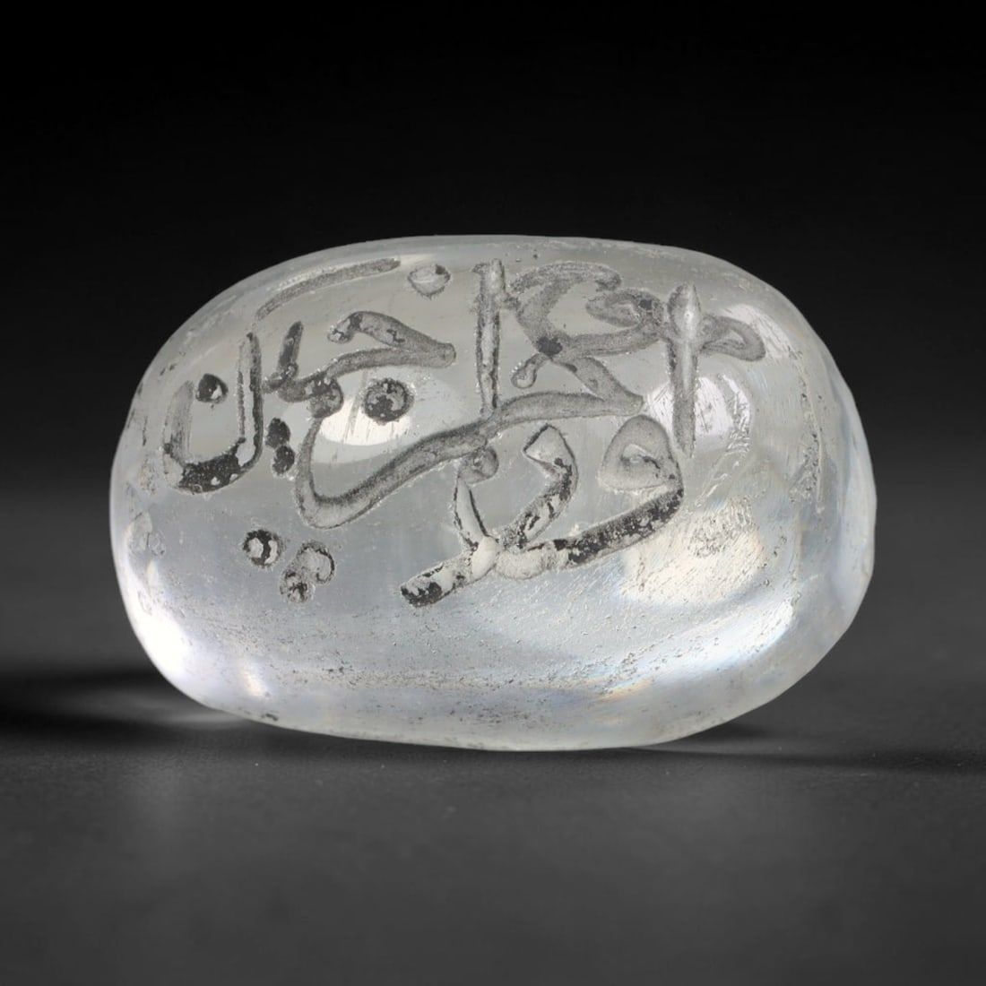 Early Vintage Islamic White Glass Calligraphic Intaglio Seal Cabochon (Post 1900 CE), 83BX: This early vintage glass intaglio seal cabochon draws from enduring Islamic seal-making traditions, formed from translucent pale glass with a smoothly rounded polished surface. The face features caref