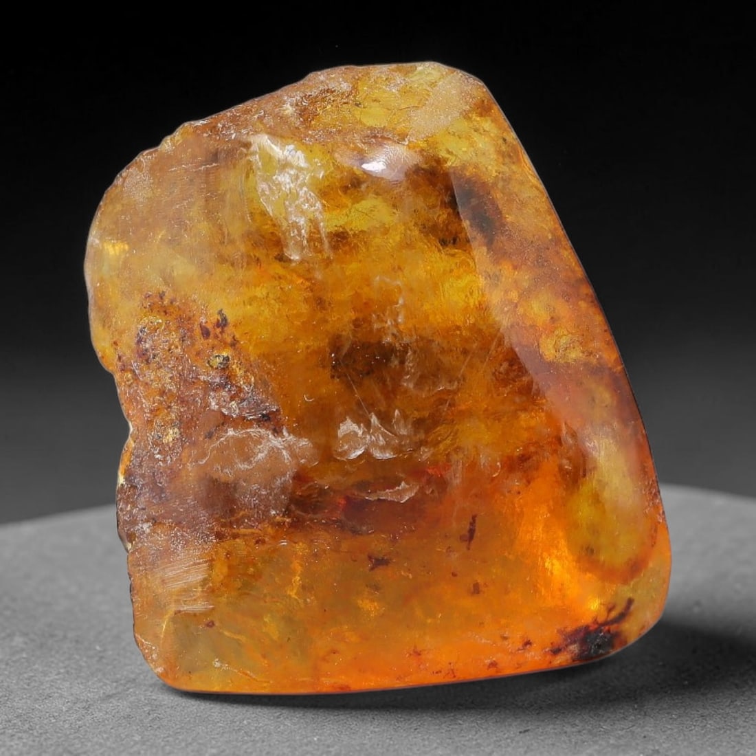 16.83ct Natural Baltic Polished Loose Freeform Amber Gemstone, 40EB: This smoothly polished freeform amber piece carries warm translucent organic clarity with fine natural fossil flecks and tiny mineral inclusions suspended throughout its 25x22mm flowing unstructured s