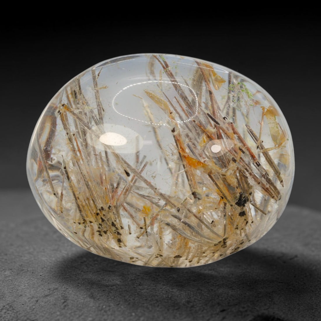 28ct Natural Brazilian Black Rutile Quartz Cabochon Loose Gemstone, 64BM: This polished cabochon of natural rutile quartz features countless distinct slender black rutile needle inclusions suspended within the clear quartz host crystal. The smooth domed surface enables full