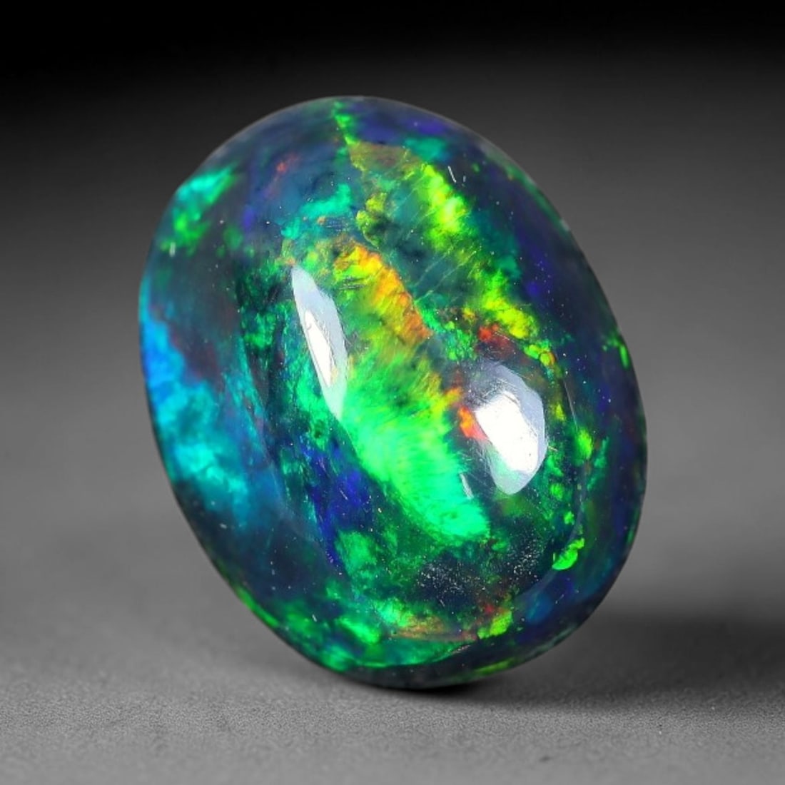 1.81ct Natural Ethiopian Welo Black Smoked Opal Cabochon Loose Gemstone, 7FX: This fully polished Ethiopian Welo opal features a dark smoked base with vivid, sweeping play-of-color shifting across its glossy dome surface, measured at 10x8x5mm. The black smoke treatment deepens 