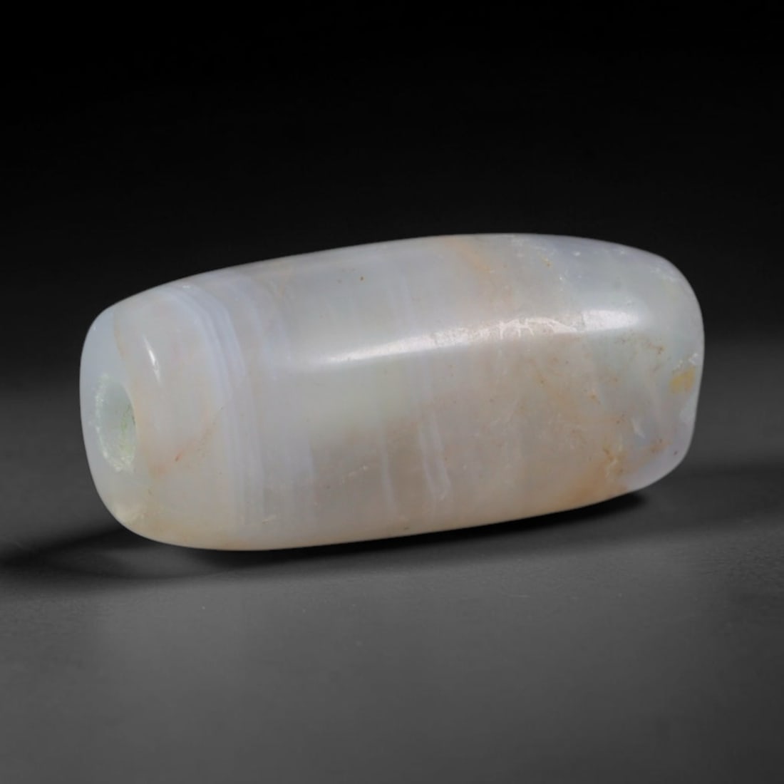 Ancient Byzantine Near Eastern Banded Agate Barrel Bead (330-1453 CE), 4AD: This antique banded agate barrel bead originates from Byzantine Near Eastern workshop traditions, which inherited late Roman chalcedony carving methods to produce ritual and personal adornment for reg