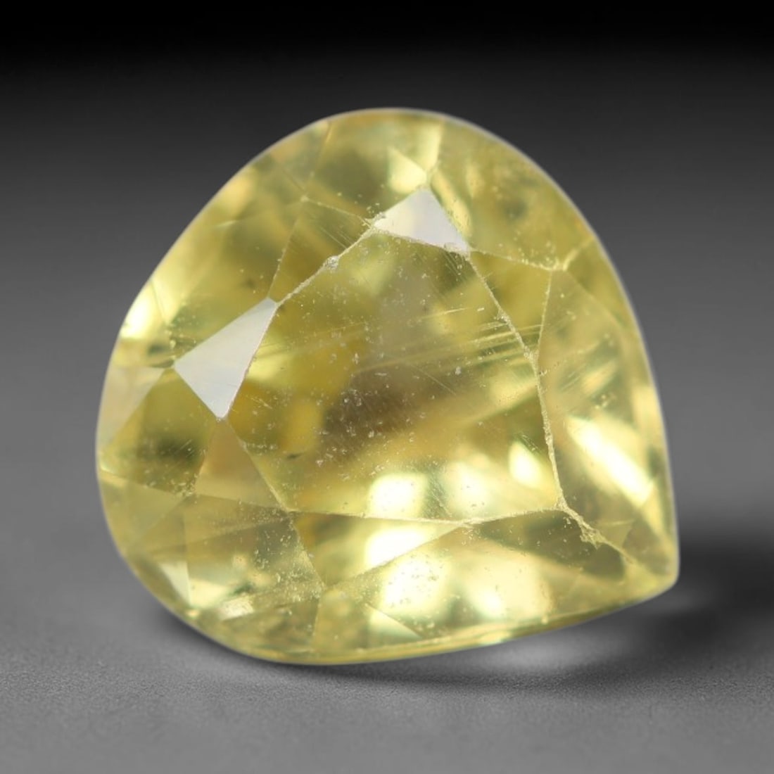 1.66ct Natural Mexican Lemon Yellow Faceted Apatite Loose Gemstone, 27AS: This expertly faceted yellow apatite holds translucent pale lemon yellow crystal structure with faint tiny internal mineral specks and subtle fine linear markings visible beneath its precisely polishe