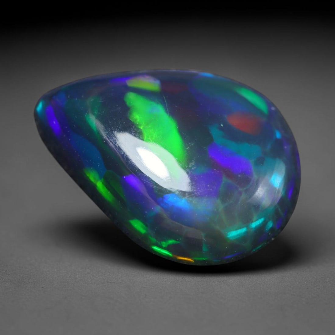 3.24ct Natural Ethiopian Welo Black Smoked Opal Cabochon Loose Gemstone, 51BY: This fully polished Ethiopian Welo opal features a dark smoked base with vivid, sweeping play-of-color shifting across its glossy dome surface, measured at 14x10x4mm. The black smoke treatment deepens