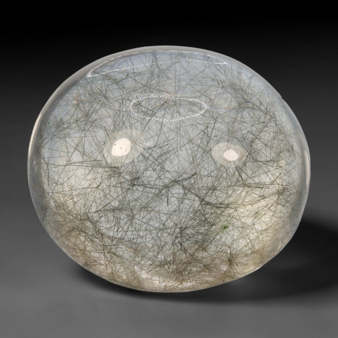 21ct Natural Brazilian Black Rutile Quartz Cabochon Loose Gemstone, 82BM: This polished cabochon of natural rutile quartz features countless distinct slender black rutile needle inclusions suspended within the clear quartz host crystal. The smooth domed surface enables full
