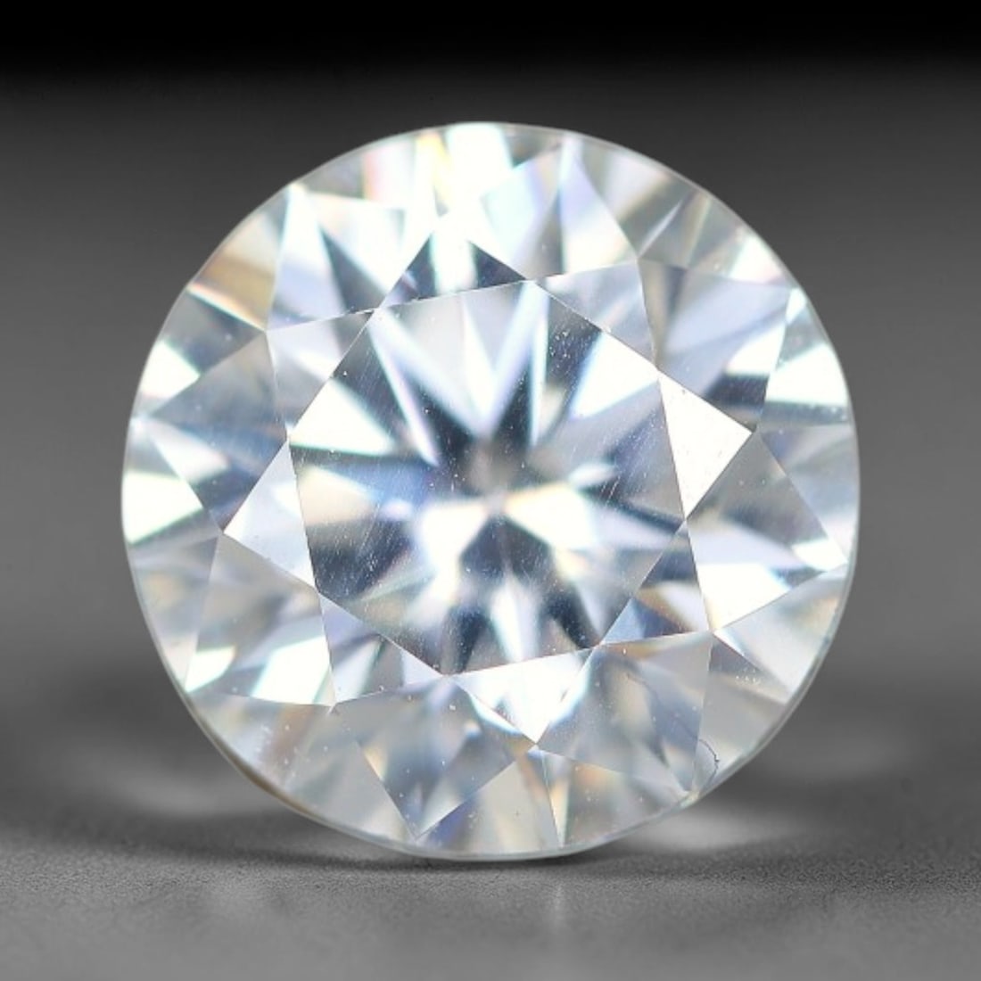 1.24 Carats Natural Cool White Moissanite Loose Gemstone, 89FM: This cool white moissanite holds dimension measurements of 6.9x4.3mm, delivering exceptional light dispersion that generates vivid rainbow sparkle across its fully transparent body, with faint microsc