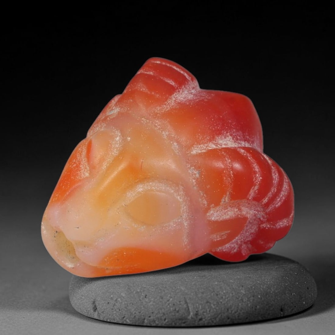Ancient Sasanian Persian Agate Ram Head Amulet Bead (224-651 CE), 43FV: This antique ram head amulet bead carved from natural agate originates from the Sasanian Persian Empire. Ram motifs stood as powerful symbols of fertility, strength and divine protection within ancien