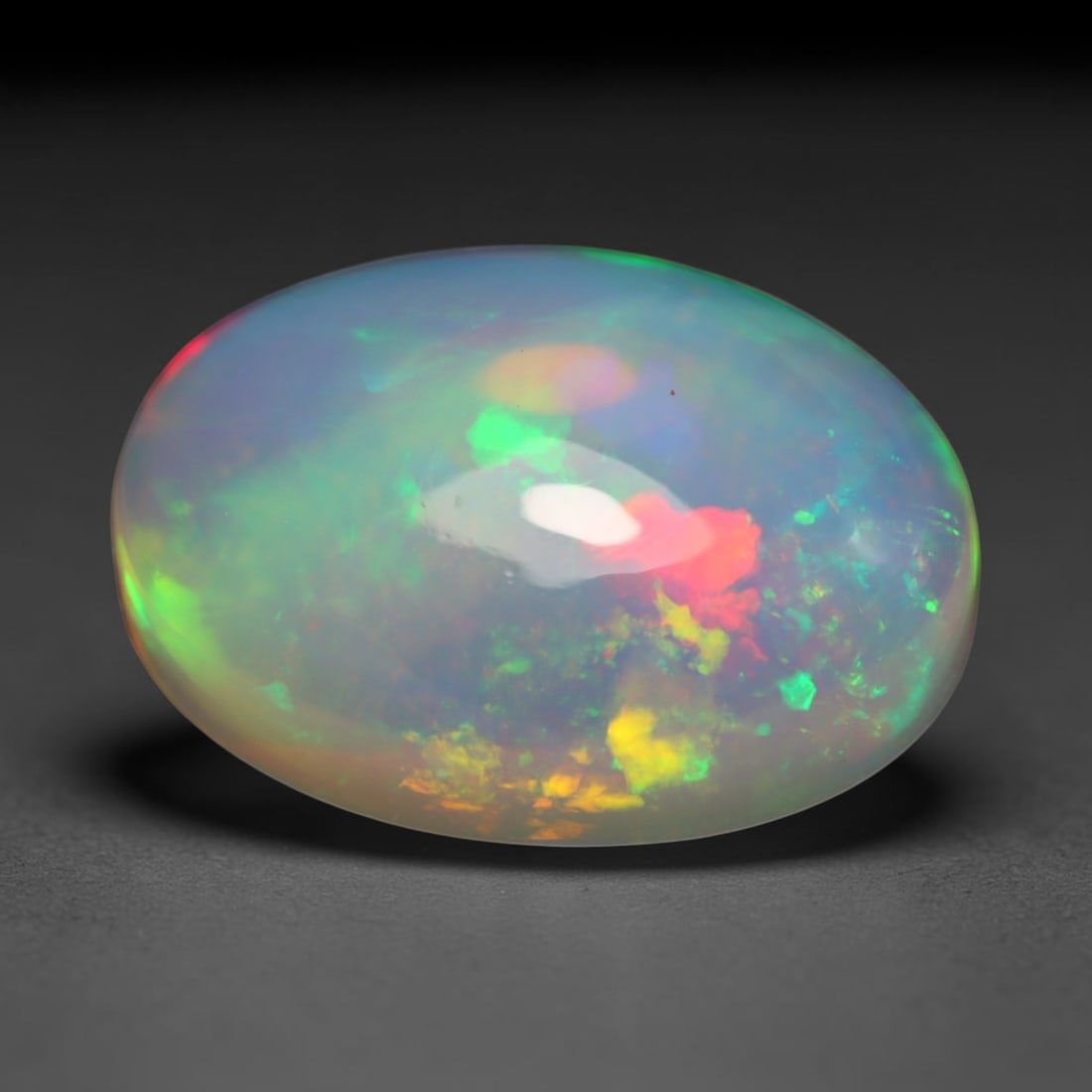 5.65ct Natural Ethiopian Welo Opal Cabochon Loose Gemstone, 35BY: This smoothly polished cabochon is genuine natural Ethiopian Welo opal. The translucent base hosts vivid multi-coloured play-of-colour, displaying dynamic flashes of multi color that shift as the view