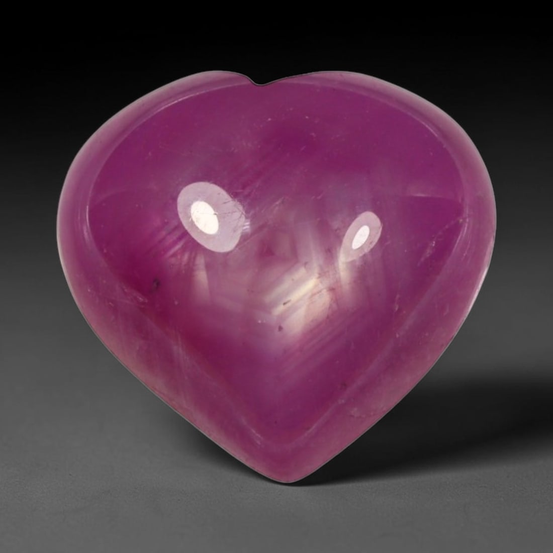 4.95ct Natural Mozambique Hot Pink Ruby Loose Gemstone, 78BP: This heart shaped Mozambique ruby cabochon measures 10.7x10.1x4.5mm, showcasing a vivid saturated hot pink body paired with stunning natural hexagonal crystal growth banding that forms a distinct geom