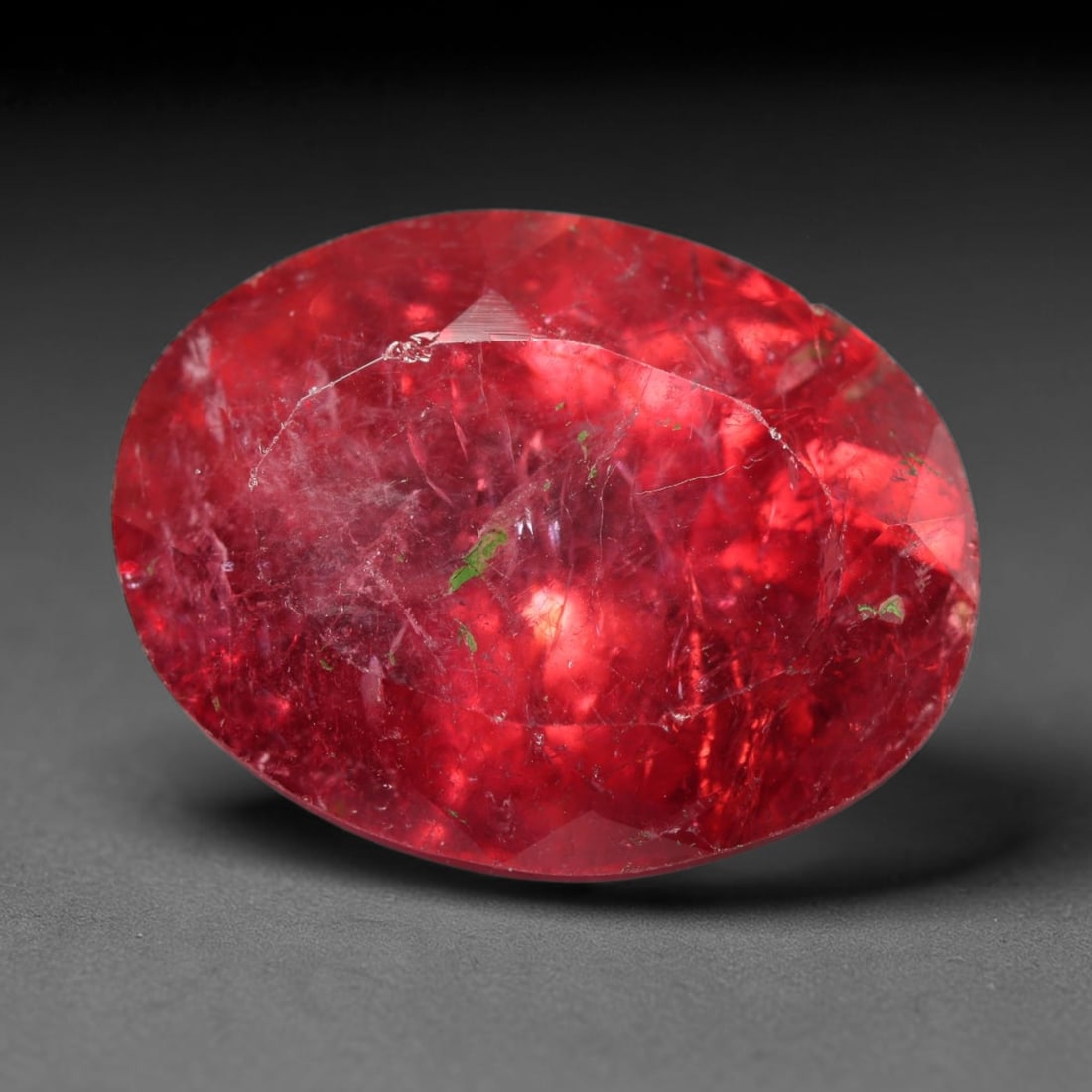 16.67ct Natural Mozambican Rubellite Tourmaline Oval Faceted Loose Gemstone, 64BZ: This precisely cut oval faceted gemstone is natural rubellite tourmaline sourced from Mozambique. It showcases striking saturated crimson-red colour throughout the crystal matrix, with distinct natura