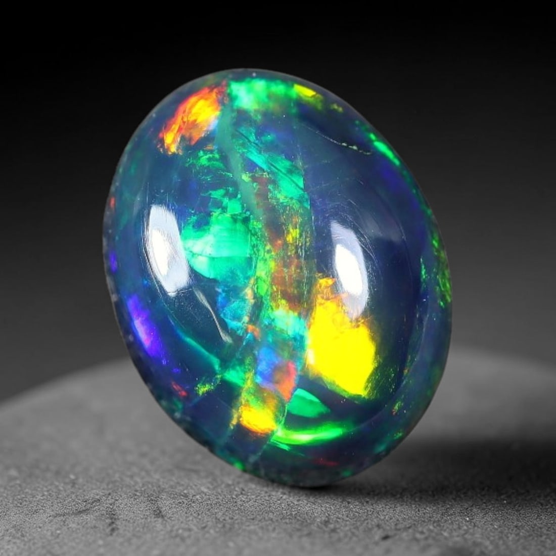 1.77ct Natural Ethiopian Welo Black Smoked Opal Cabochon Loose Gemstone, 51FX: This fully polished Ethiopian Welo opal features a dark smoked base with vivid, sweeping play-of-color shifting across its glossy dome surface, measured at 9x7x5mm. The black smoke treatment deepens t
