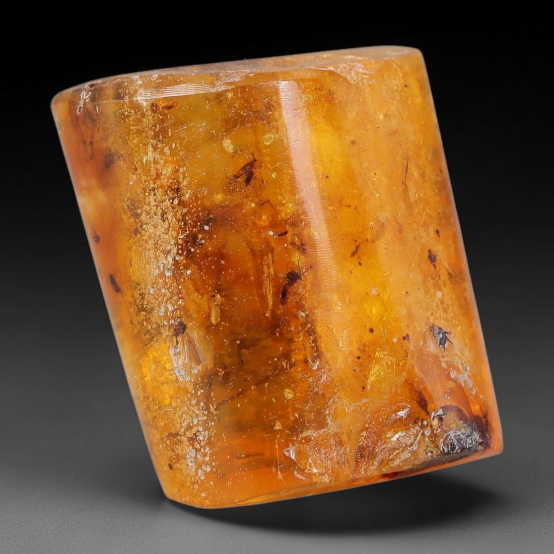 19.74ct Natural Baltic Polished Loose Freeform Amber Gemstone, 100AT: This smoothly polished freeform amber piece carries warm translucent organic clarity with fine natural fossil flecks and tiny mineral inclusions suspended throughout its 22x18mm flowing unstructured s