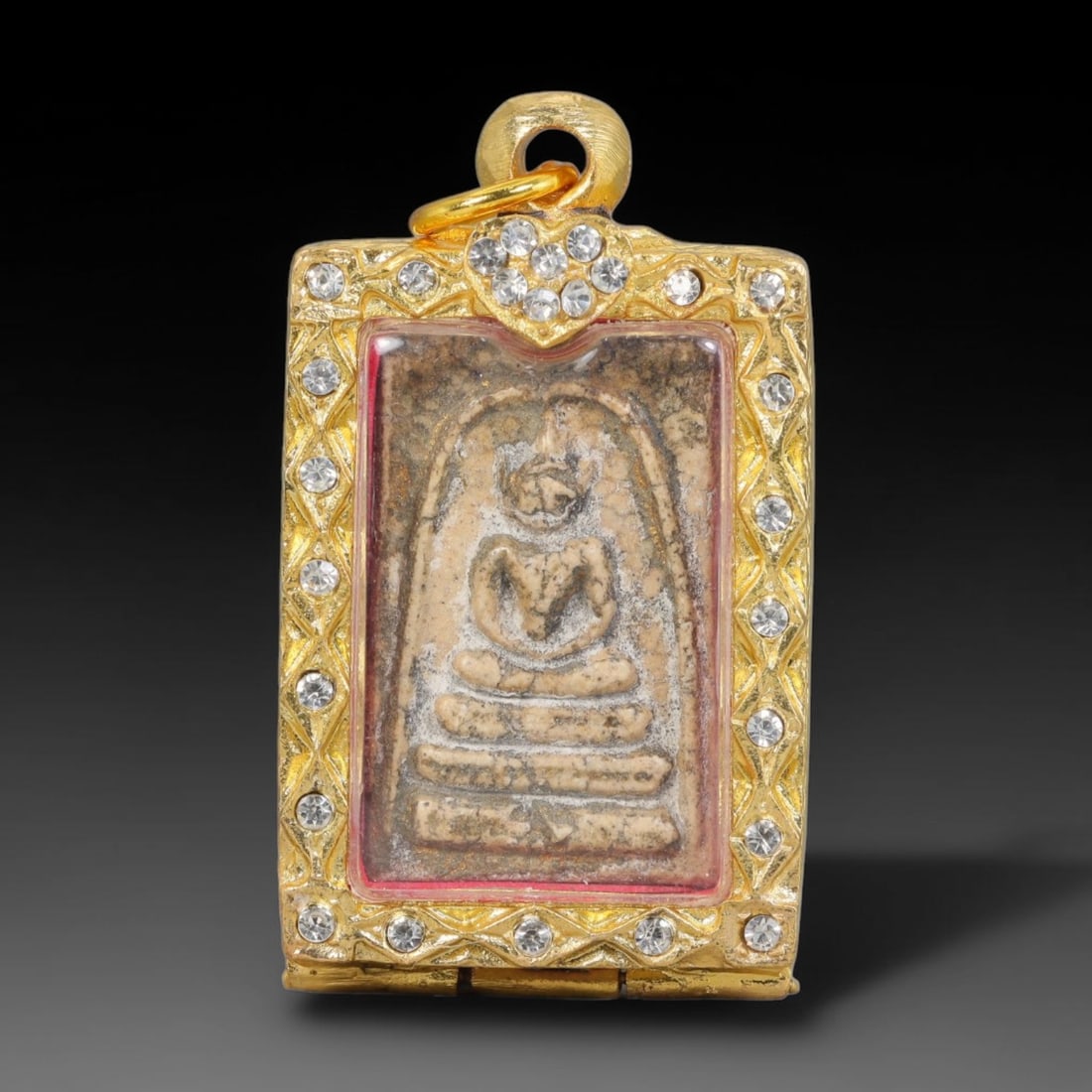 Thai Buddhist Folk Tradition Enclosed Amulet Pendant with Decorative Metal Casing, 6AH: This Thai sacred amulet is housed within an ornate hinged metal protective casing fitted with a top loop for wear as a pendant. The casing features intricate embossed surface detailing and a continuou