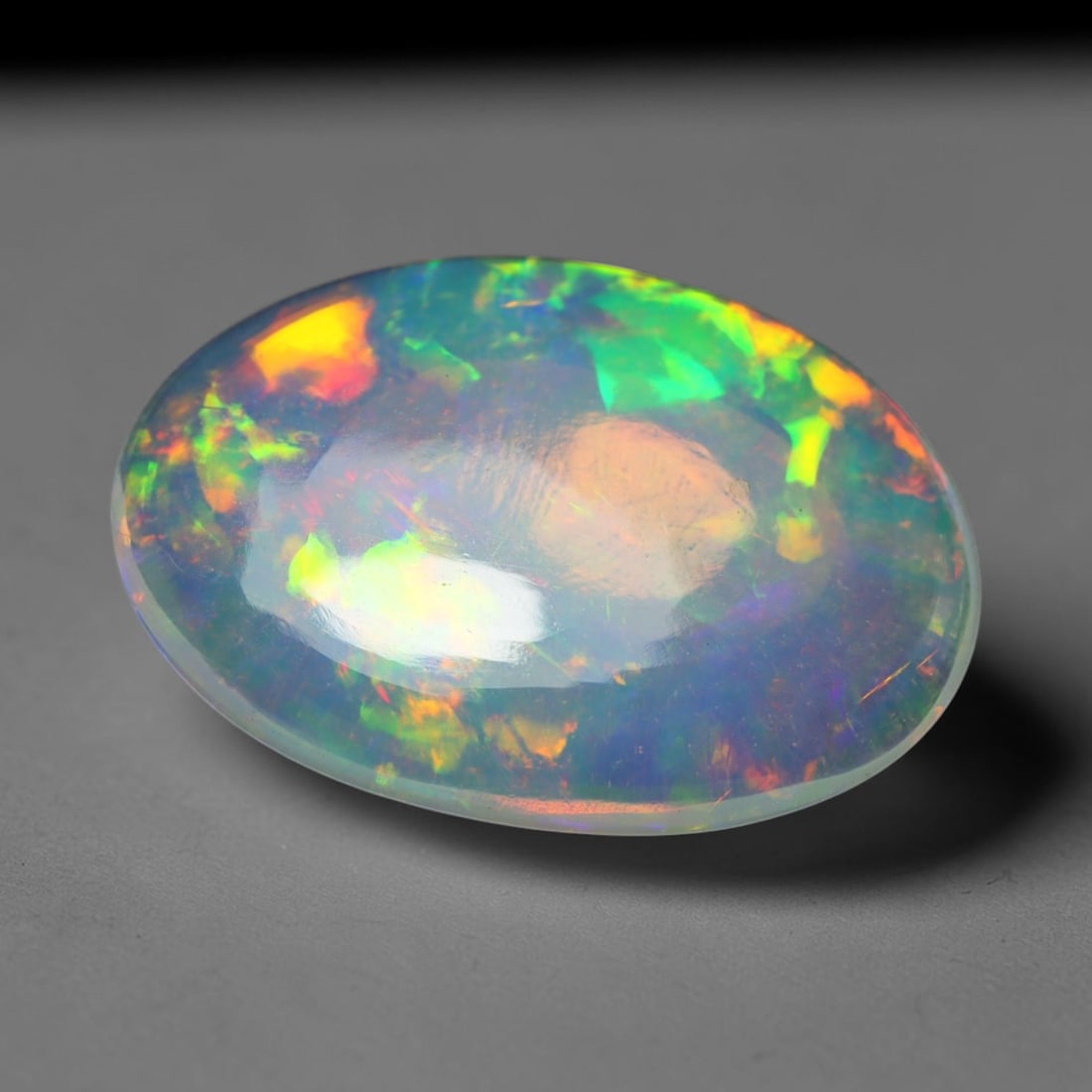 4.00ct Natural Ethiopian Welo Opal Cabochon Loose Gemstone, 31BY: This smoothly polished cabochon is genuine natural Ethiopian Welo opal. The translucent base hosts vivid multi-coloured play-of-colour, displaying dynamic flashes of multi color that shift as the view