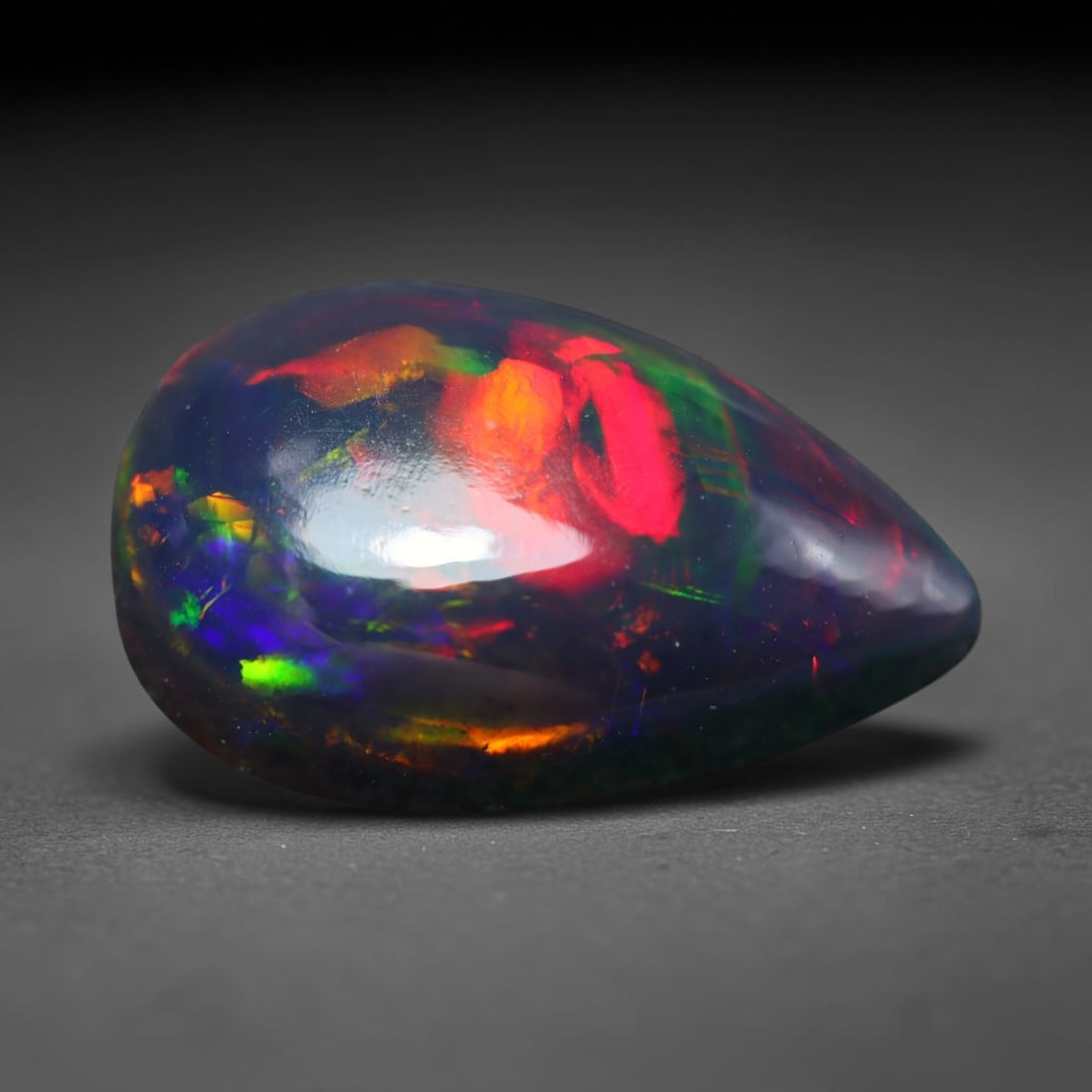 3.34ct Natural Ethiopian Welo Black Smoked Opal Cabochon Loose Gemstone, 26BY: This fully polished Ethiopian Welo opal features a dark smoked base with vivid, sweeping play-of-color shifting across its glossy dome surface, measured at 15x9x5mm. The black smoke treatment deepens 