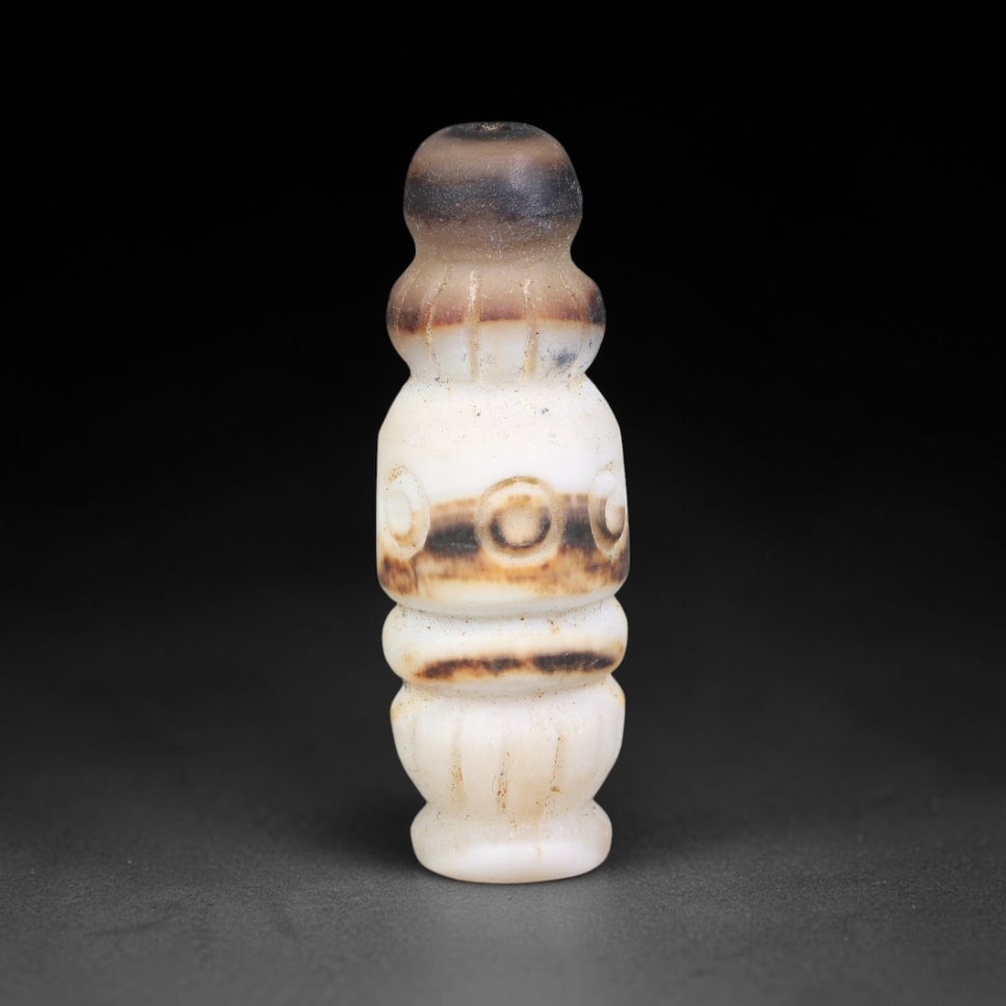 Ancient Medieval Seljuk Persian Banded Agate Composite Talisman Bead (1037-1307 CE), 7EC: This antique composite shaped banded agate bead originates from Seljuk Persian culture, celebrated for crafting elaborate figural and segmented talisman beads favoured by nobility along medieval Silk 
