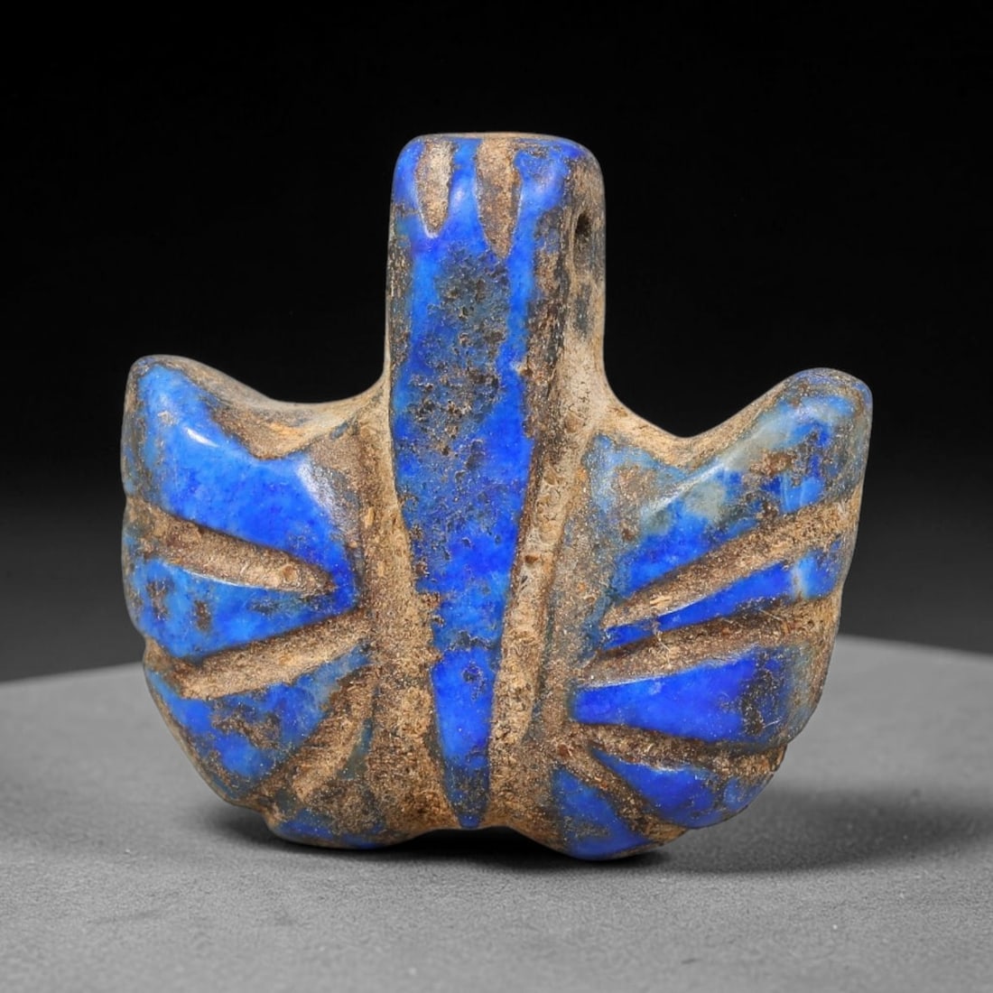 Ancient Sasanian Persian Lapis Lazuli Winged Amulet Bead (224-651 CE), 27EC: This antique winged amulet bead is carved from natural lapis lazuli originating from the Sasanian Persian Empire, renowned for crafting symbolic talisman pendants for Zoroastrian protective rituals an