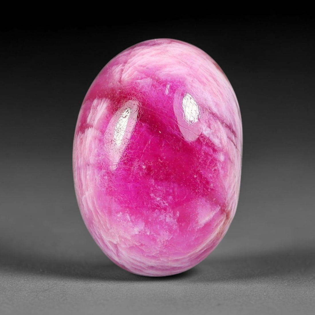 12.59 Carats Natural Mozambique Vivid Pink Red Ruby Loose Gemstone, 76FG: This polished Mozambique ruby cabochon measures 15.3x11x6.4mm, featuring striking natural swirling white mineral banding layered across a rich saturated pink red base that creates a unique organic art