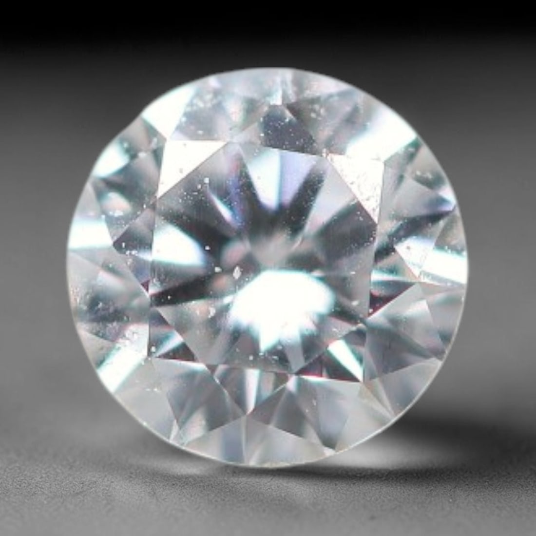 0.13ct Lab-Grown White Round Brilliant HPHT Diamond Loose Gemstone, 78BE: This precision-cut HPHT lab-grown diamond exhibits brilliant colourless transparency, dotted with subtle microscopic growth features within its crystal structure, measured at calibrated dimensions of 