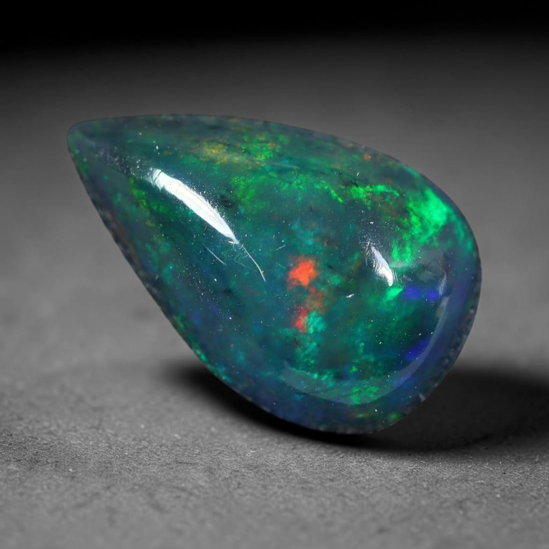 2.61ct Natural Ethiopian Welo Black Smoked Opal Cabochon Loose Gemstone, 44FX: This fully polished Ethiopian Welo opal features a dark smoked base with vivid, sweeping play-of-color shifting across its glossy dome surface, measured at 14x8x5mm. The black smoke treatment deepens 
