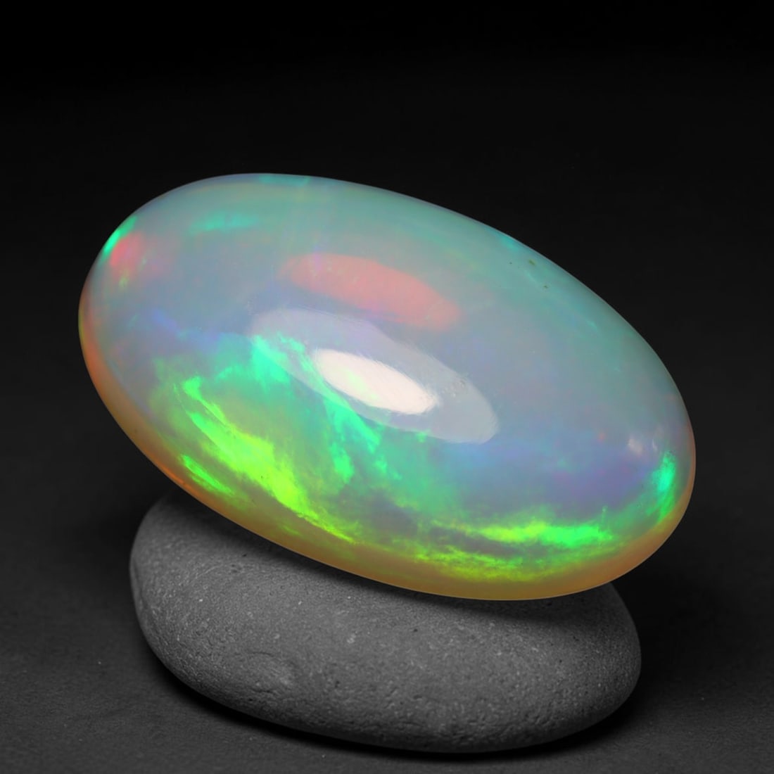 3.93ct Natural Ethiopian Welo Opal Cabochon Loose Gemstone, 38BY: This smoothly polished cabochon is genuine natural Ethiopian Welo opal. The translucent base hosts vivid multi-coloured play-of-colour, displaying dynamic flashes of multi color that shift as the view