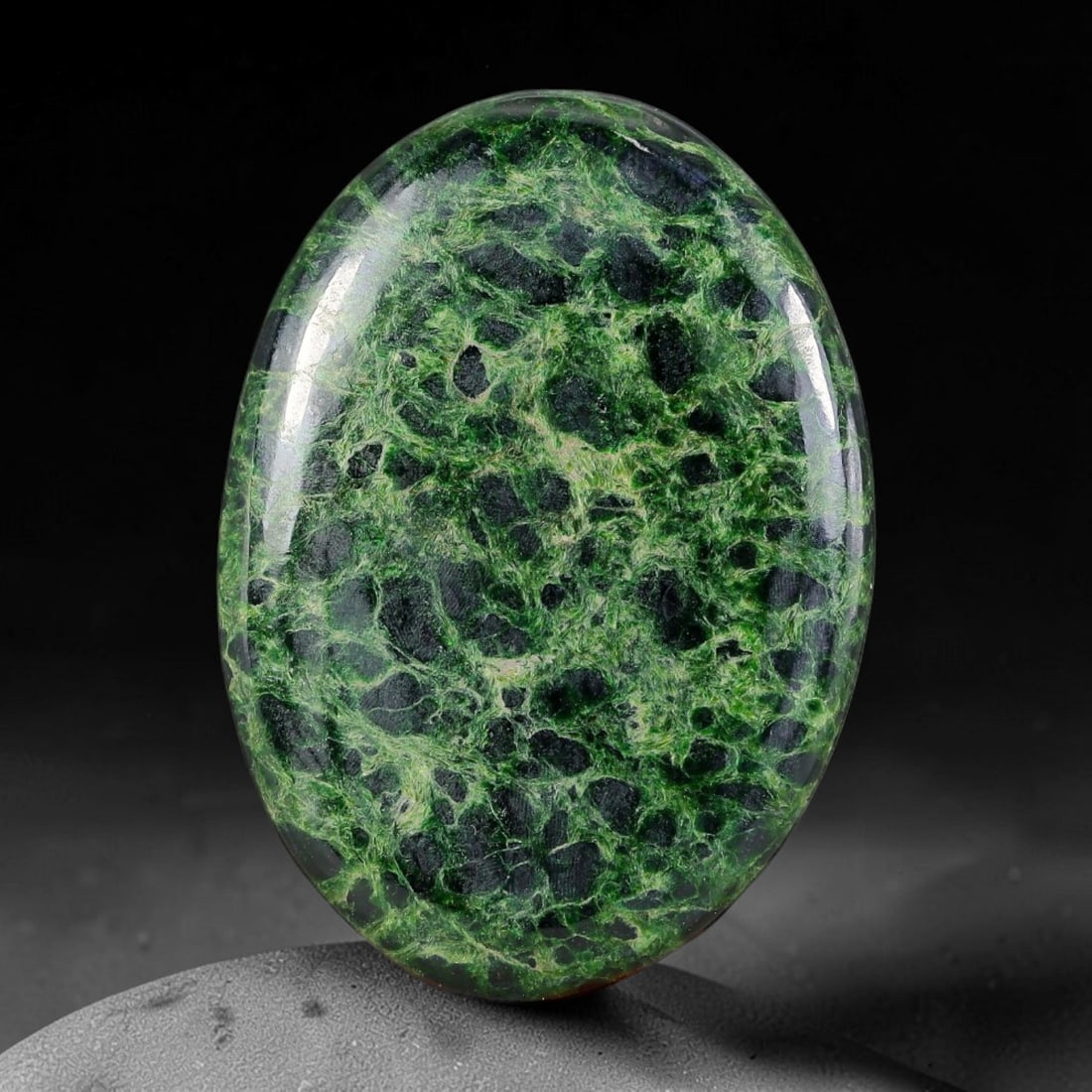 21ct Natural Burmese Type A Black Web Lace Green Jadeite Jade Cabochon, 22FA: This single fully untreated natural Burmese Type A oval jadeite jade cabochon weighs 21ct with dimensions of 29.4x21x3.2mm. Bright fibrous grass-green veins form an intricate lace web structure wrappi