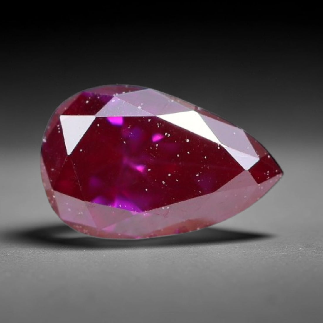 0.13ct Natural Fancy Deep Pink Diamond Loose Gemstone, 24BH: This polished natural fancy diamond features rich deep pink colouration, measured at calibrated dimensions of 4.3x2.7x1.6mm. Carefully proportioned pear faceting delivers dynamic light movement, highl