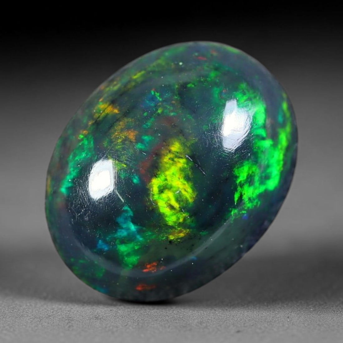 2.27ct Natural Ethiopian Welo Black Smoked Opal Cabochon Loose Gemstone, 20FX: This fully polished Ethiopian Welo opal features a dark smoked base with vivid, sweeping play-of-color shifting across its glossy dome surface, measured at 11x8x5mm. The black smoke treatment deepens 