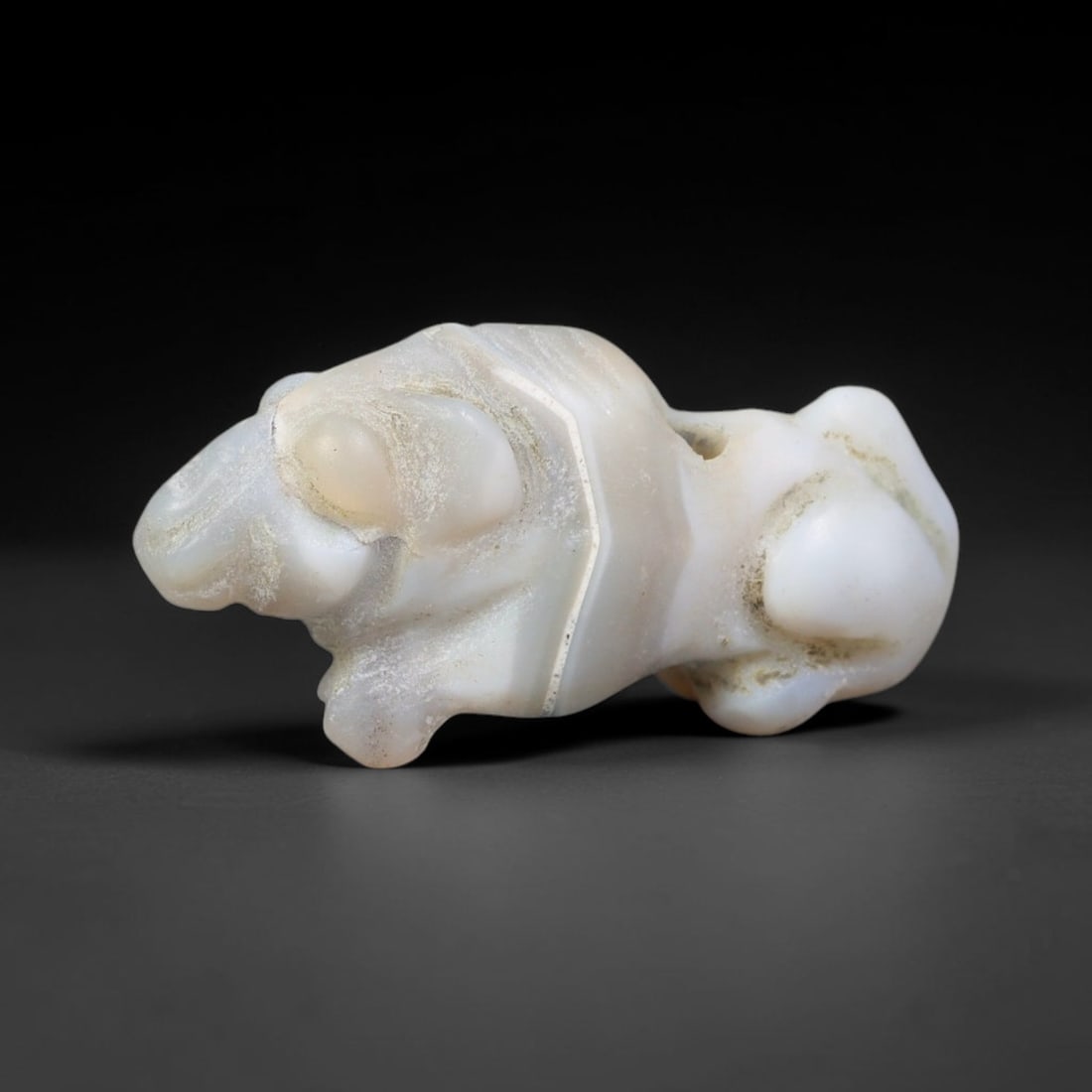 Ancient Sasanian Persian Banded Agate Feline Amulet Bead (224-651 CE), 5EC: This antique recumbent feline amulet bead carved from natural banded agate originates from the Sasanian Persian Empire, where zoomorphic talismans served as symbols of guardianship and protection for 