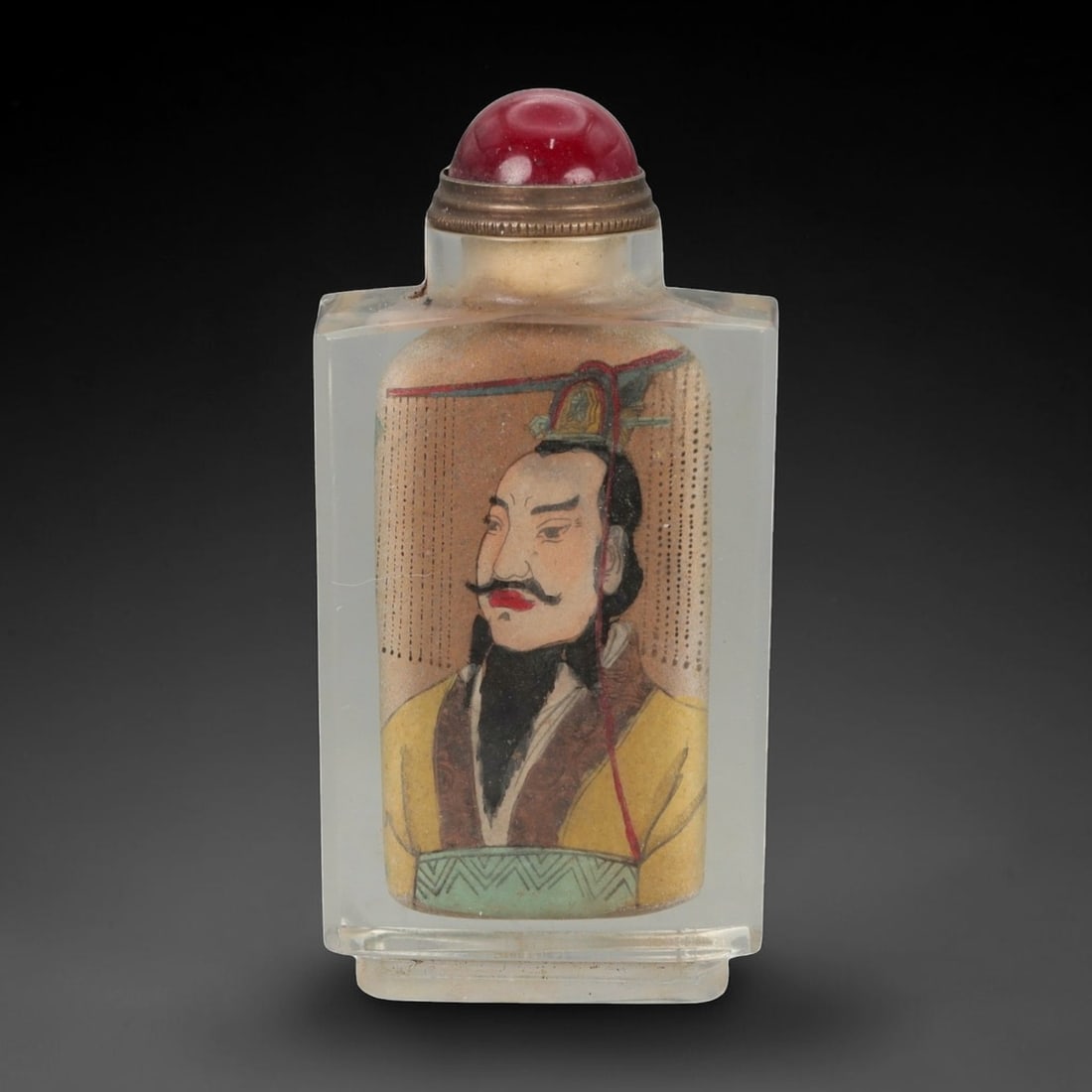 A Chinese Crystal Glass Snuff Bottle, 63FG: The snuff bottle is formed from clear crystal glass and of flattened rectangular form, rising from a narrow foot to a short cylindrical neck with a flat rim. One side is inside-painted with a frontal 