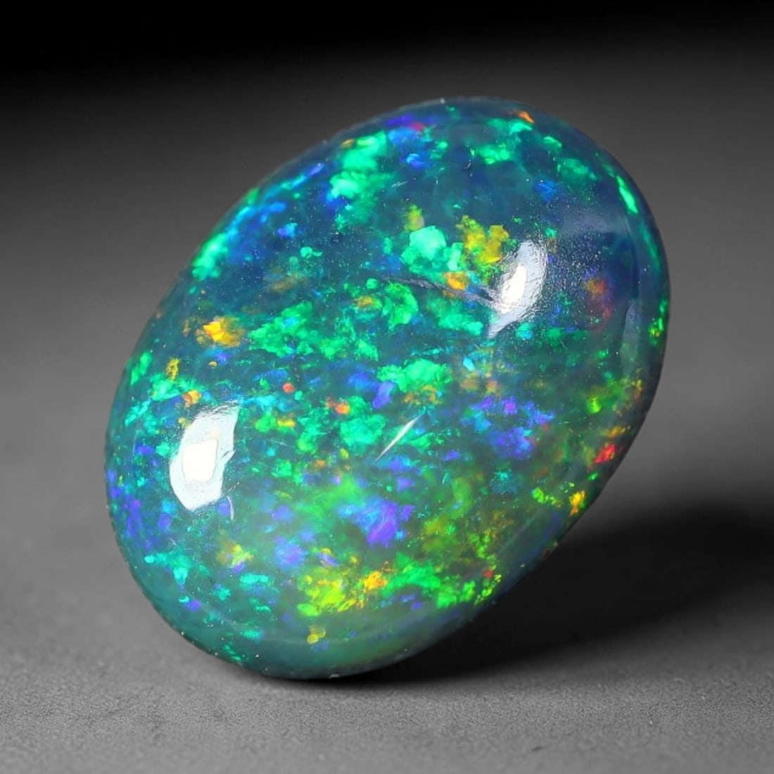 2.26ct Natural Ethiopian Welo Black Smoked Opal Cabochon Loose Gemstone, 60FX: This fully polished Ethiopian Welo opal features a dark smoked base with vivid, sweeping play-of-color shifting across its glossy dome surface, measured at 11x8x4mm. The black smoke treatment deepens 