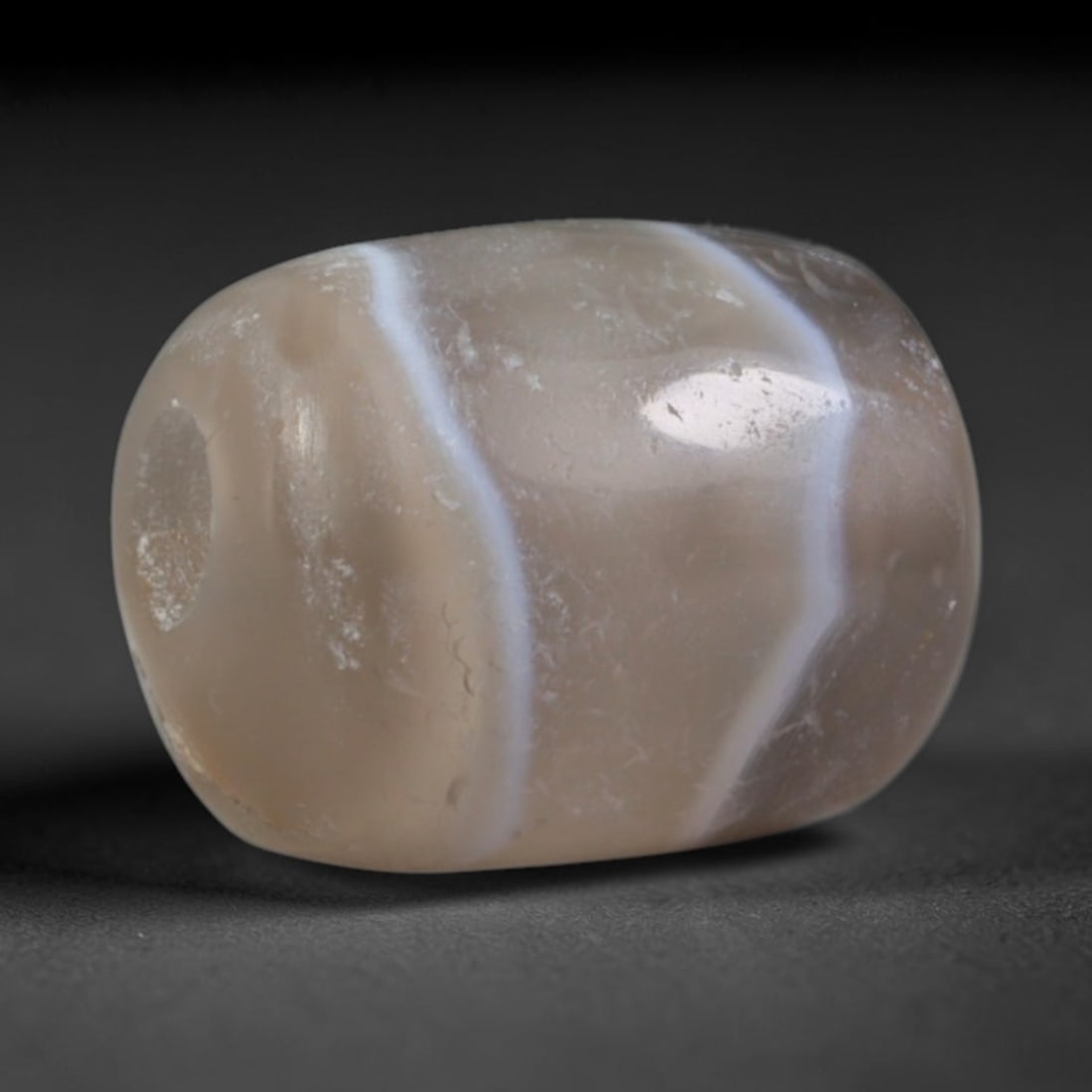 Ancient Early Historic Indian Kingdoms Banded Agate Barrel Bead (322 BCE-550 CE), 16AD: This antique banded agate barrel bead originates from the Early Historic Indian Kingdoms spanning the Maurya, Shunga and Gupta Empires, cultures that refined agate bead craftsmanship for royal regalia