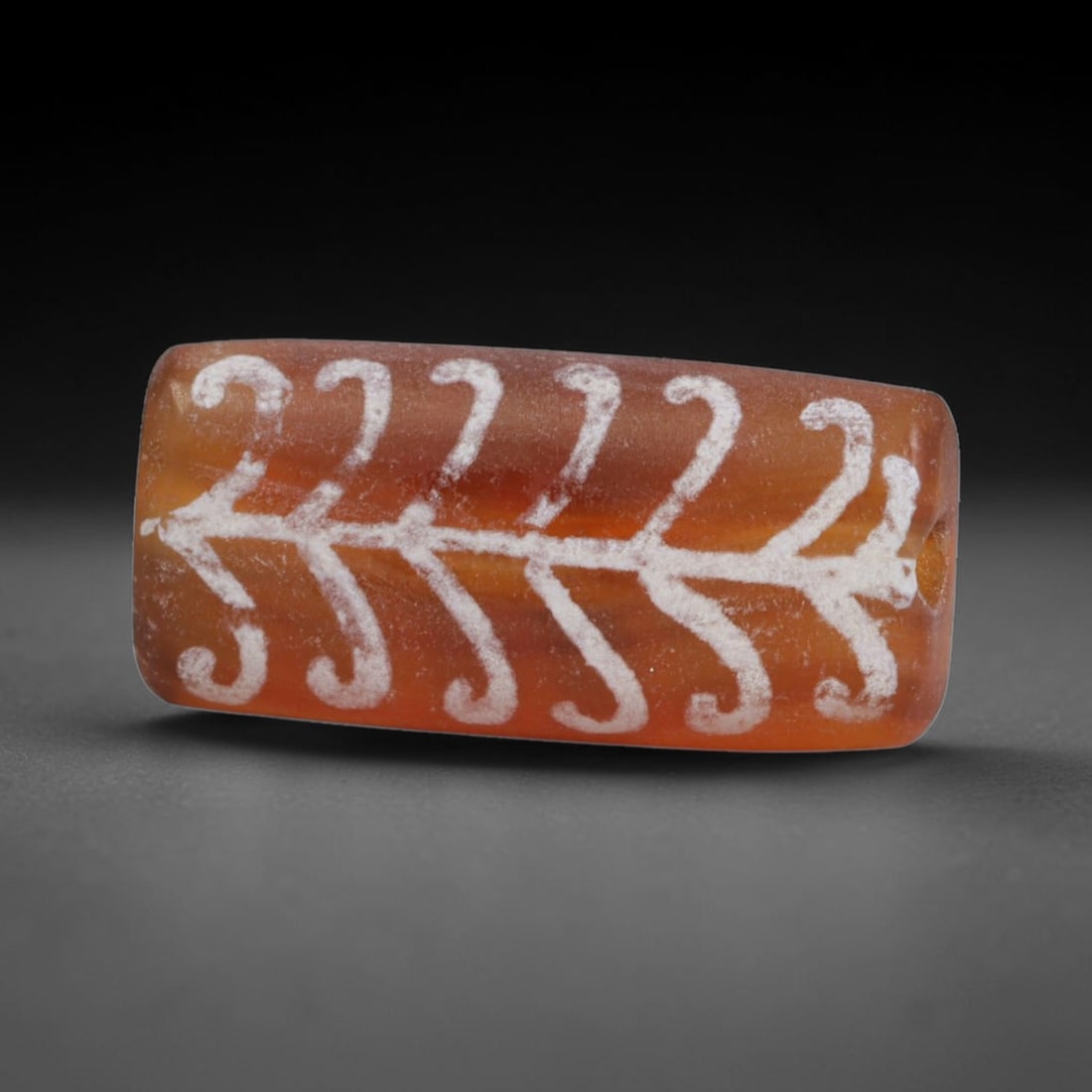 Antique Sino-Himalayan Region Etched Carnelian Bead, 85EG: Antique etched carnelian bead originating from the Sino-Himalayan region. Exhibits characteristic surface patina and traditional etched white decoration. Dimensions: 18x9mm, fully pierced for suspensi