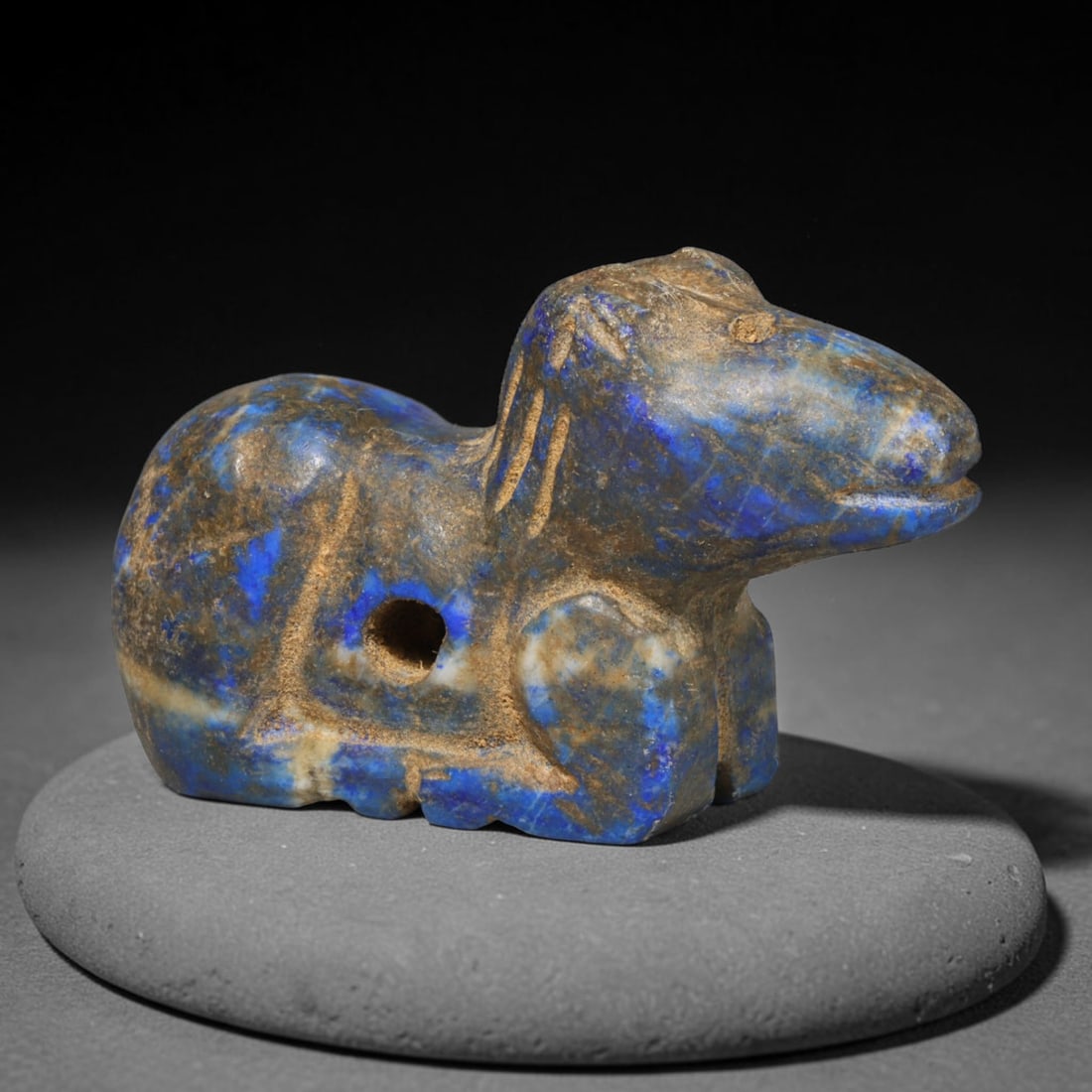 Ancient Bactrian Lapis Lazuli Feline Amulet (250 BCE-200 CE), 54ED: This carved lapis lazuli recumbent feline amulet originates from Greco-Bactrian Culture, a vital Silk Road civilization blending Hellenistic and Central Asian artistic traditions. Simplified incised d
