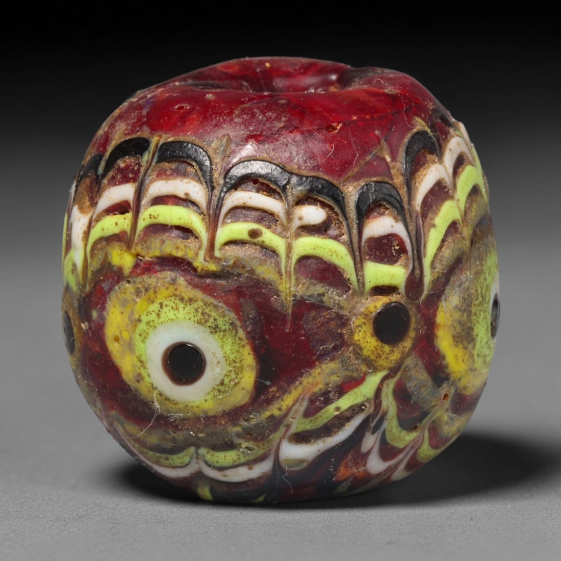 Ancient Medieval Islamic Mosaic Glass Bead (800-1200 CE), 71ED: This antique mosaic glass bead originates from the medieval Islamic world, a celebrated tradition of intricate polychrome glass bead production used for personal adornment and talismanic wear. The dee