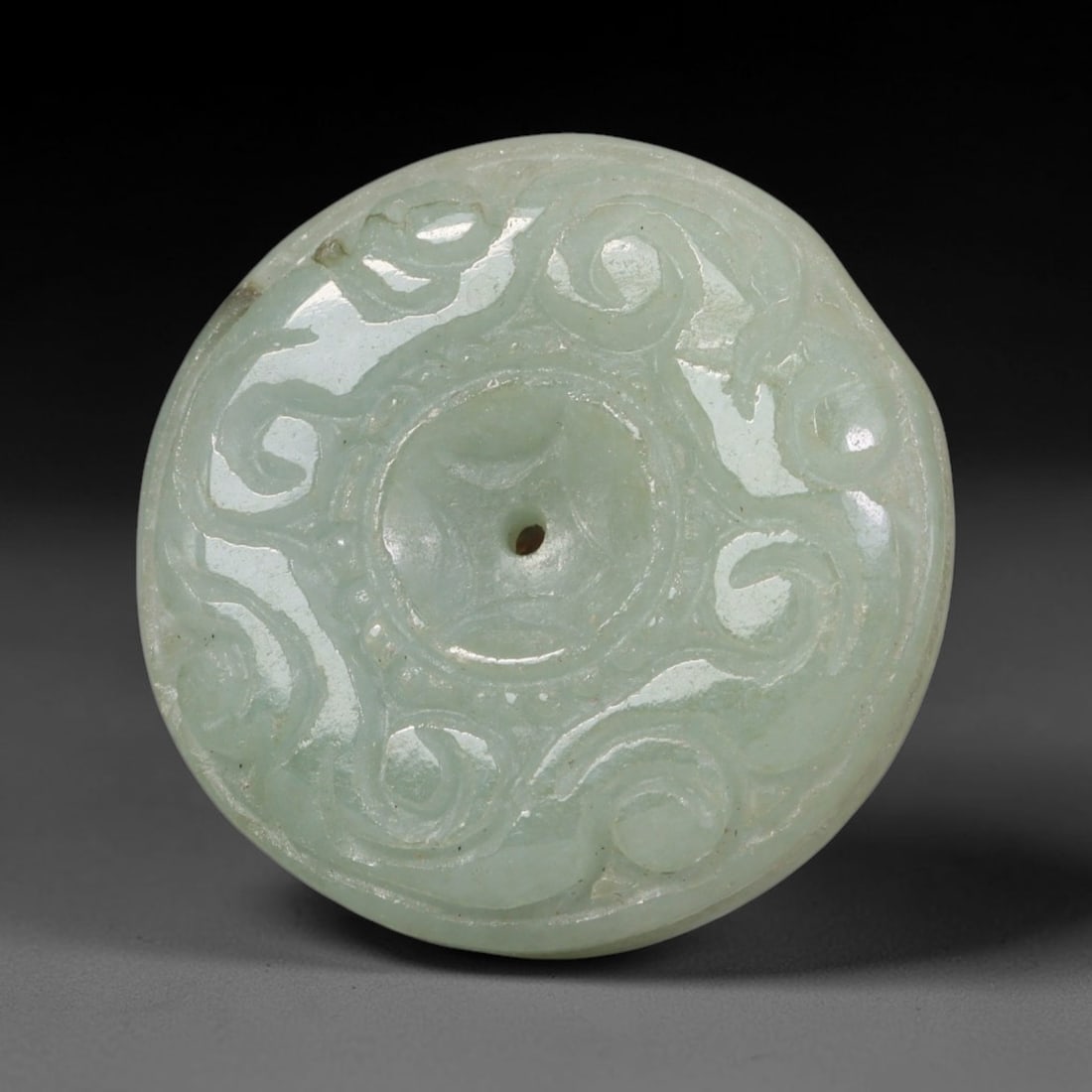 Natural Burmese Type A Jadeite Jade Carved Disc Pendant, 58BP: Artisan hand-carved untreated Burmese Type A jadeite jade circular disc pendant with a 26 mm diameter. The surface is adorned with detailed traditional relief carving finished with a smooth polished s