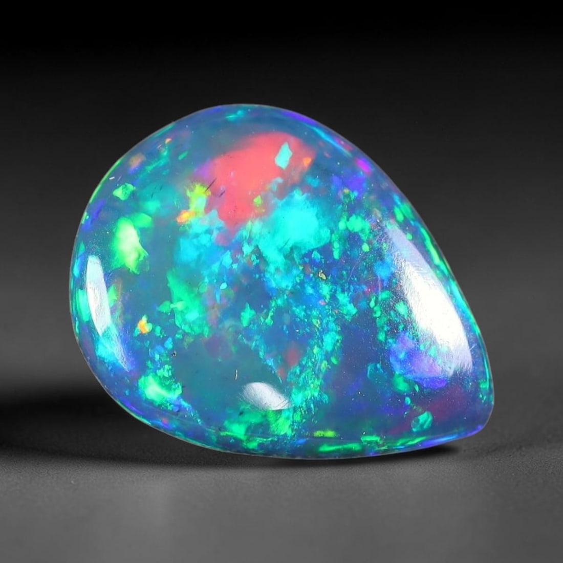 1.36ct Natural Ethiopian Welo Black Smoked Opal Cabochon Loose Gemstone, 36FX: This fully polished Ethiopian Welo opal features a dark smoked base with vivid, sweeping play-of-color shifting across its glossy dome surface, measured at 11x8x3mm. The black smoke treatment deepens 