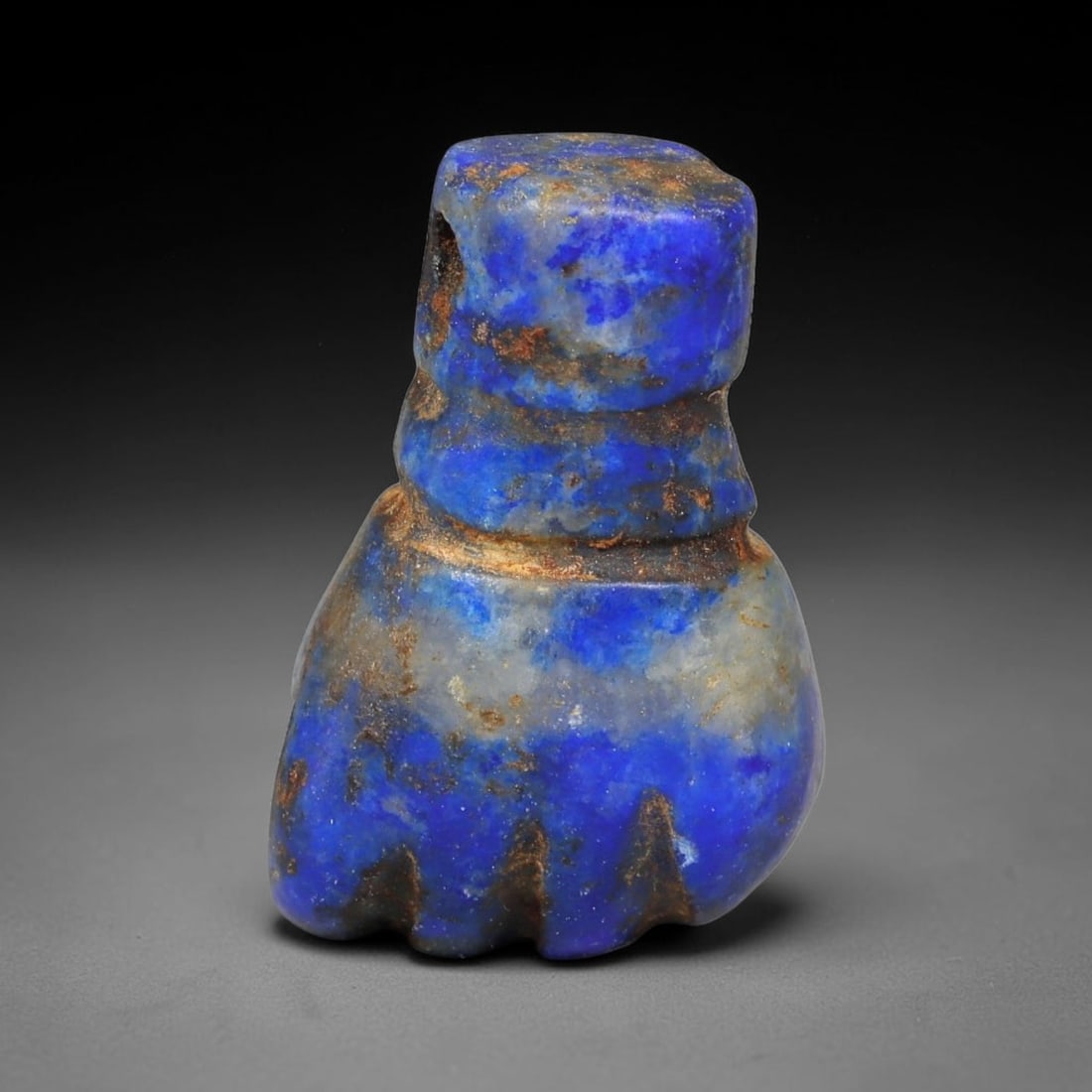 Ancient Sasanian Persian Lapis Lazuli Fist Amulet Bead (224-651 CE), 15EC: This antique fist-shaped amulet bead carved from natural lapis lazuli originates from the Sasanian Persian Empire, where clenched fist talismans symbolized strength, protection and ward against negati