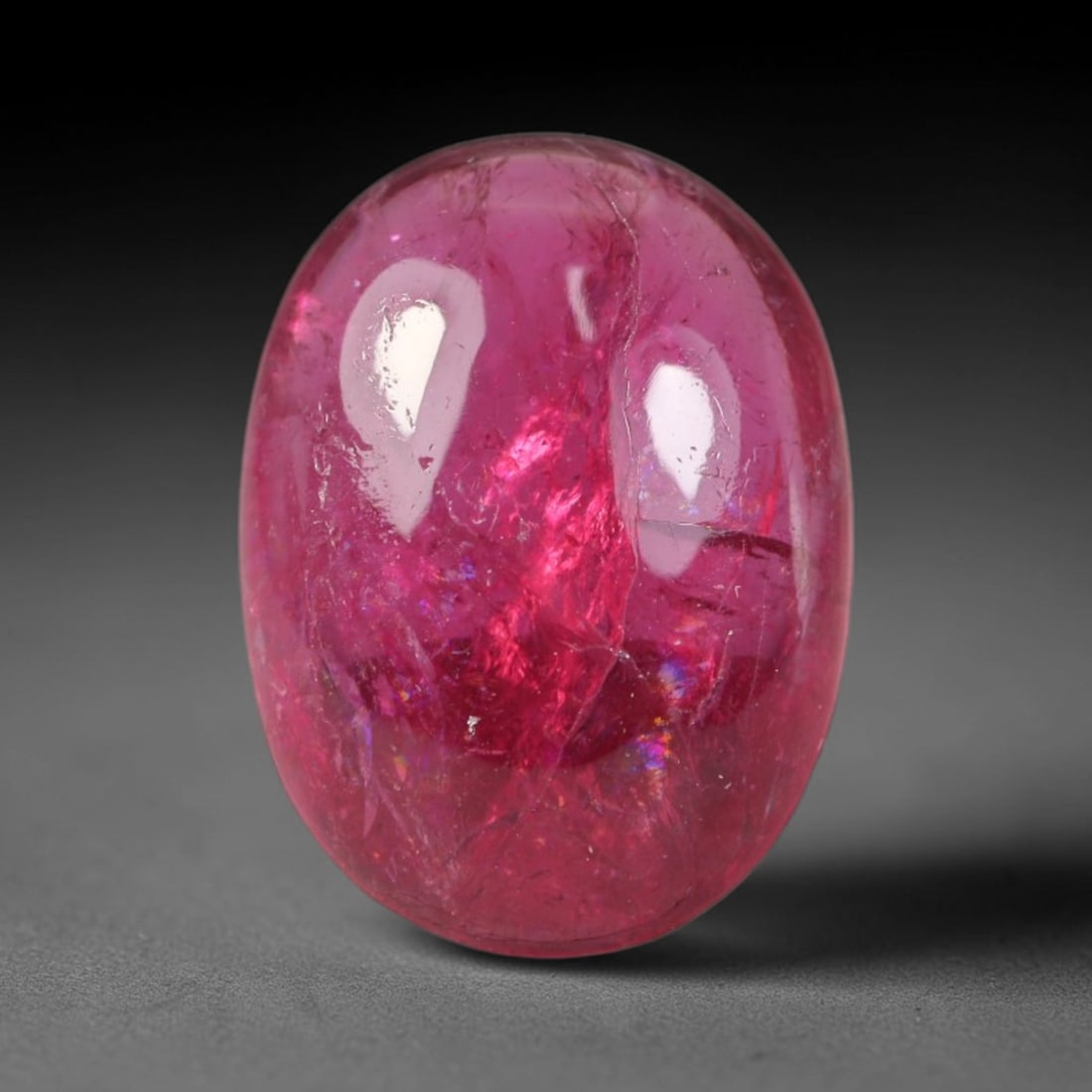 2.97ct Natural Brazilian Rubellite Tourmaline Cabochon Loose Gemstone, 20BC: This smoothly polished cabochon rubellite tourmaline features layered saturated pink-red body saturation with dense natural crystalline mineral flecks and fine internal fracture markings concentrated 