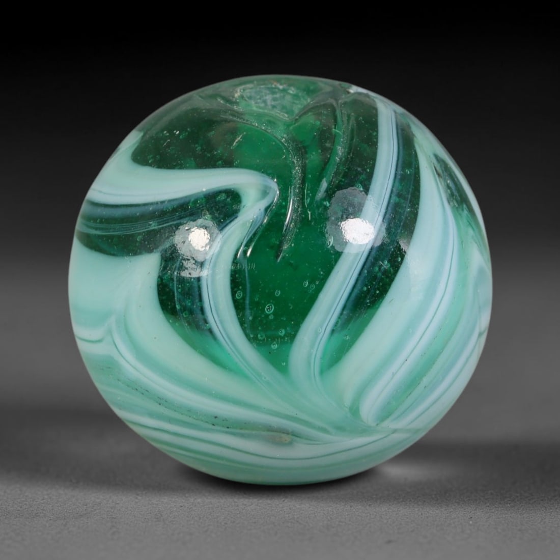 Vintage Swirled Green Blown Glass Bead - Handmade Spherical Ornament, 28AE: Hand-blown glass composes this spherical bead, defined by fluid layered swirls of deep emerald green, soft mint green and opaque white glass forming continuous marbled striations across its polished e