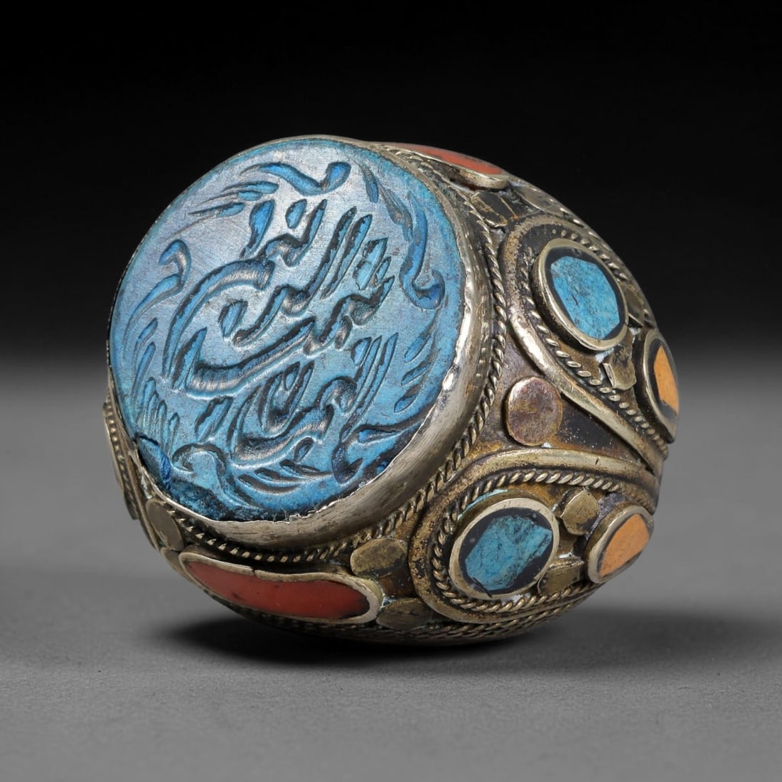 Vintage Islamic Handcrafted Silver Plated Calligraphic Talisman Statement Ring, 11BX: This vintage hand-wrought Islamic statement ring features a central engraved panel bearing traditional calligraphic detailing, set within an ornate silver-plated metal band. The mounting is enriched w