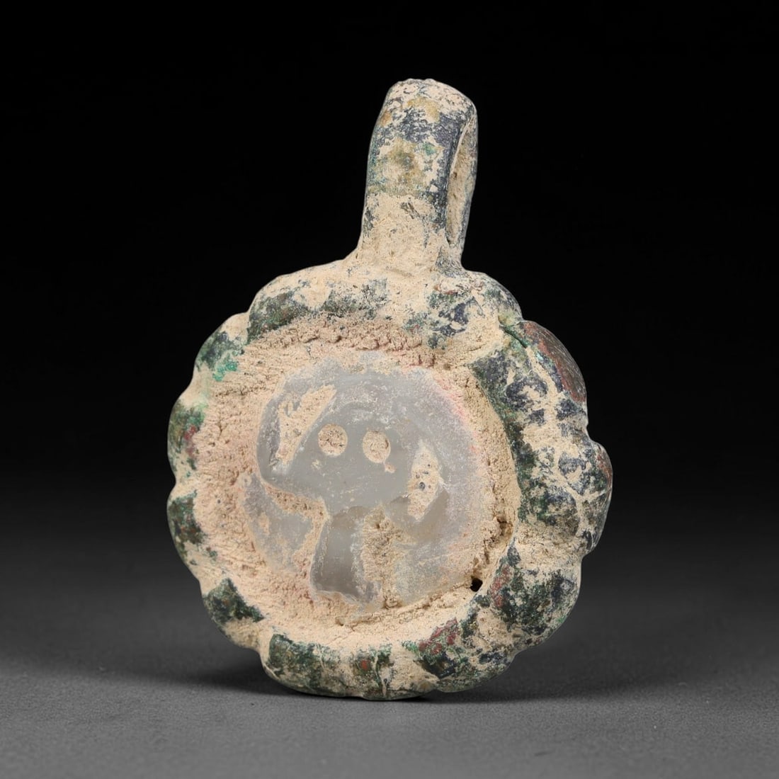 Ancient Medieval Byzantine Bronze Pendant With Stone Cameo (500-1200 CE), 68EH: This antique circular bronze pendant originates from medieval Byzantine cultural tradition, set with an inset carved stone cameo and made to serve as a wearable protective personal amulet. The bronze 
