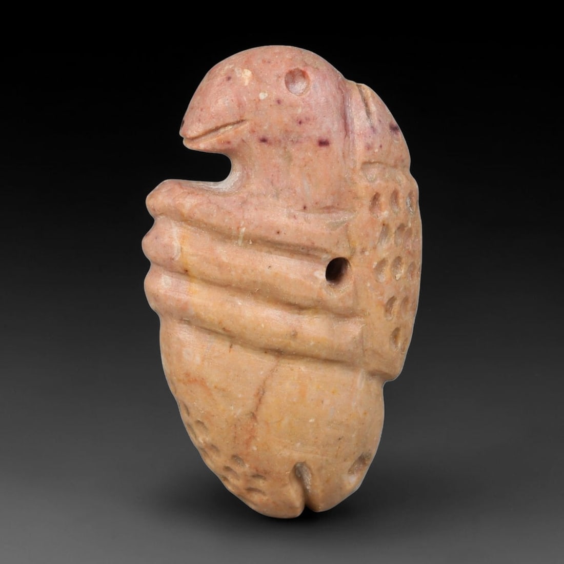 Ancient Medieval Seljuk Pink Stone Stylized Bird Talisman Amulet (11th-13th Centuries CE), 25EF: This wearable zoomorphic amulet is carved from pale pink stone, originating from the Seljuk Persian realm of the medieval Islamic Near East. It features a stylized avian form with simplified carved de