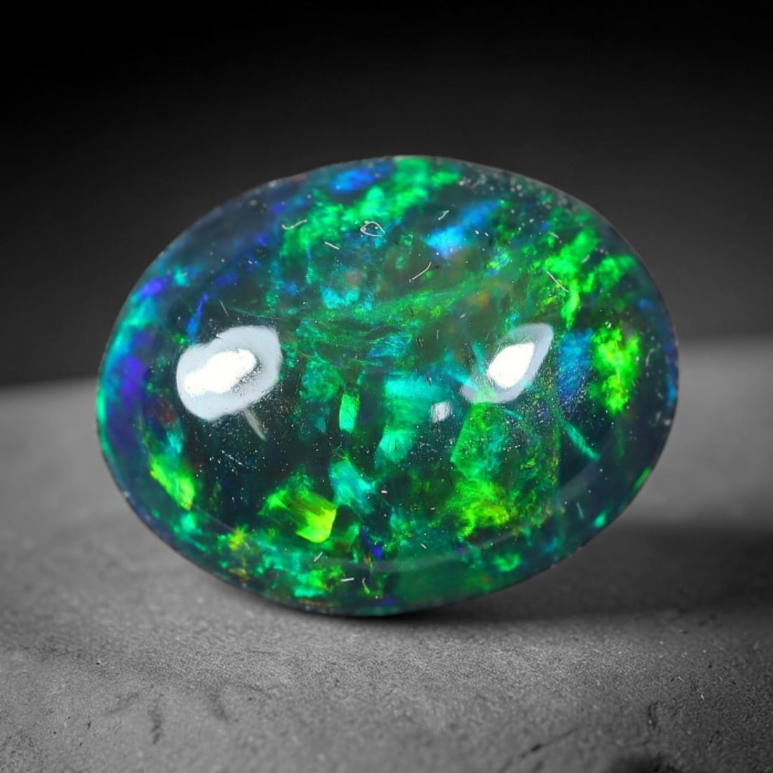 1.93ct Natural Ethiopian Welo Black Smoked Opal Cabochon Loose Gemstone, 4FX: This fully polished Ethiopian Welo opal features a dark smoked base with vivid, sweeping play-of-color shifting across its glossy dome surface, measured at 11x8x4mm. The black smoke treatment deepens 