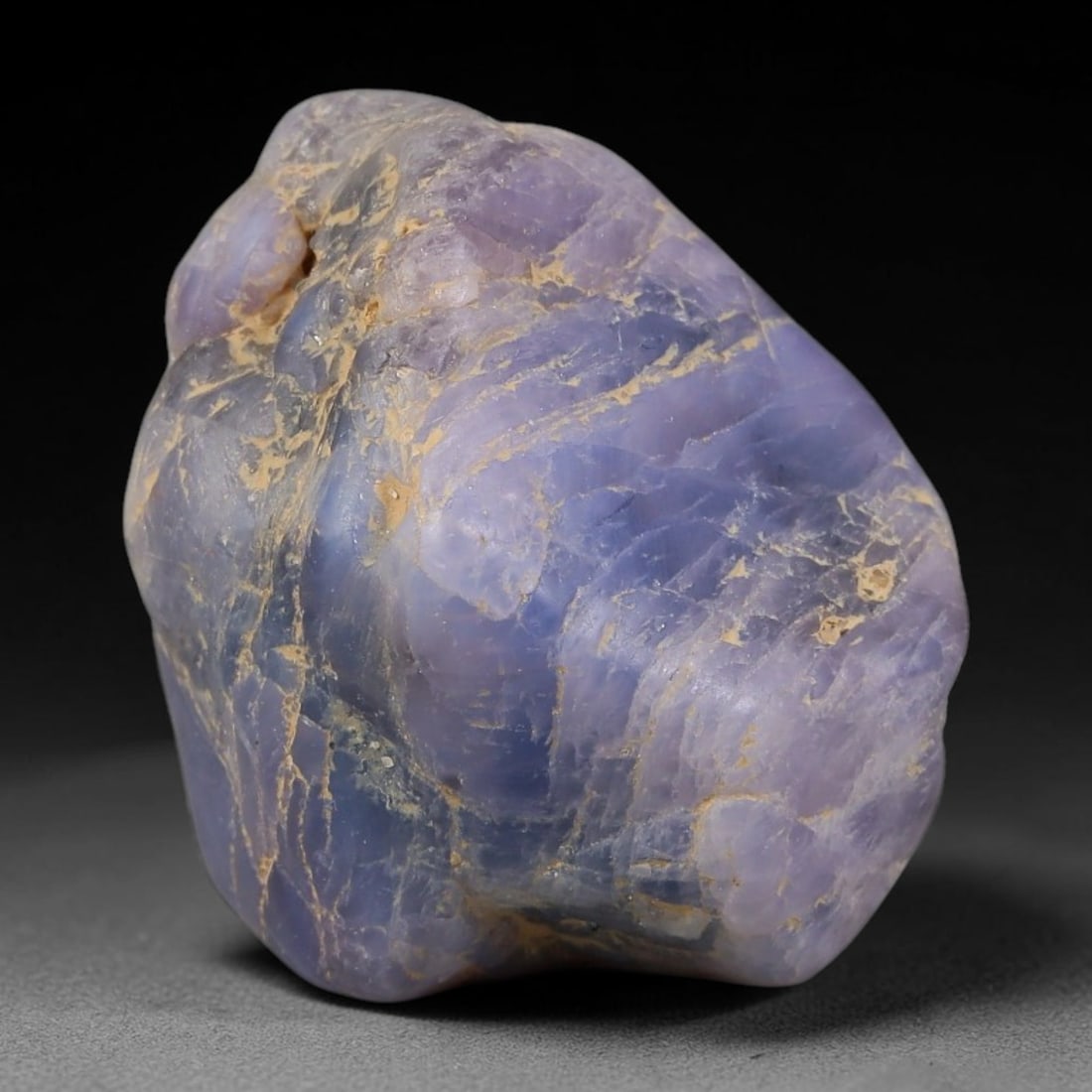 60.94ct Natural Unheated Sri Lankan Purplish Blue Sapphire Rough, 50FC: This natural corundum rough is an unheated purplish blue sapphire sourced from Sri Lankan alluvial gem deposits, featuring an irregular natural native form with residual pale yellow-brown mineral matr