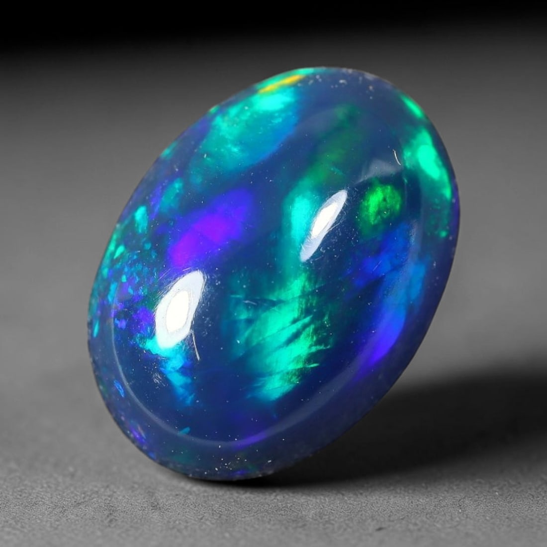 2.18ct Natural Ethiopian Welo Black Smoked Opal Cabochon Loose Gemstone, 72FX: This fully polished Ethiopian Welo opal features a dark smoked base with vivid, sweeping play-of-color shifting across its glossy dome surface, measured at 12x8x4mm. The black smoke treatment deepens 