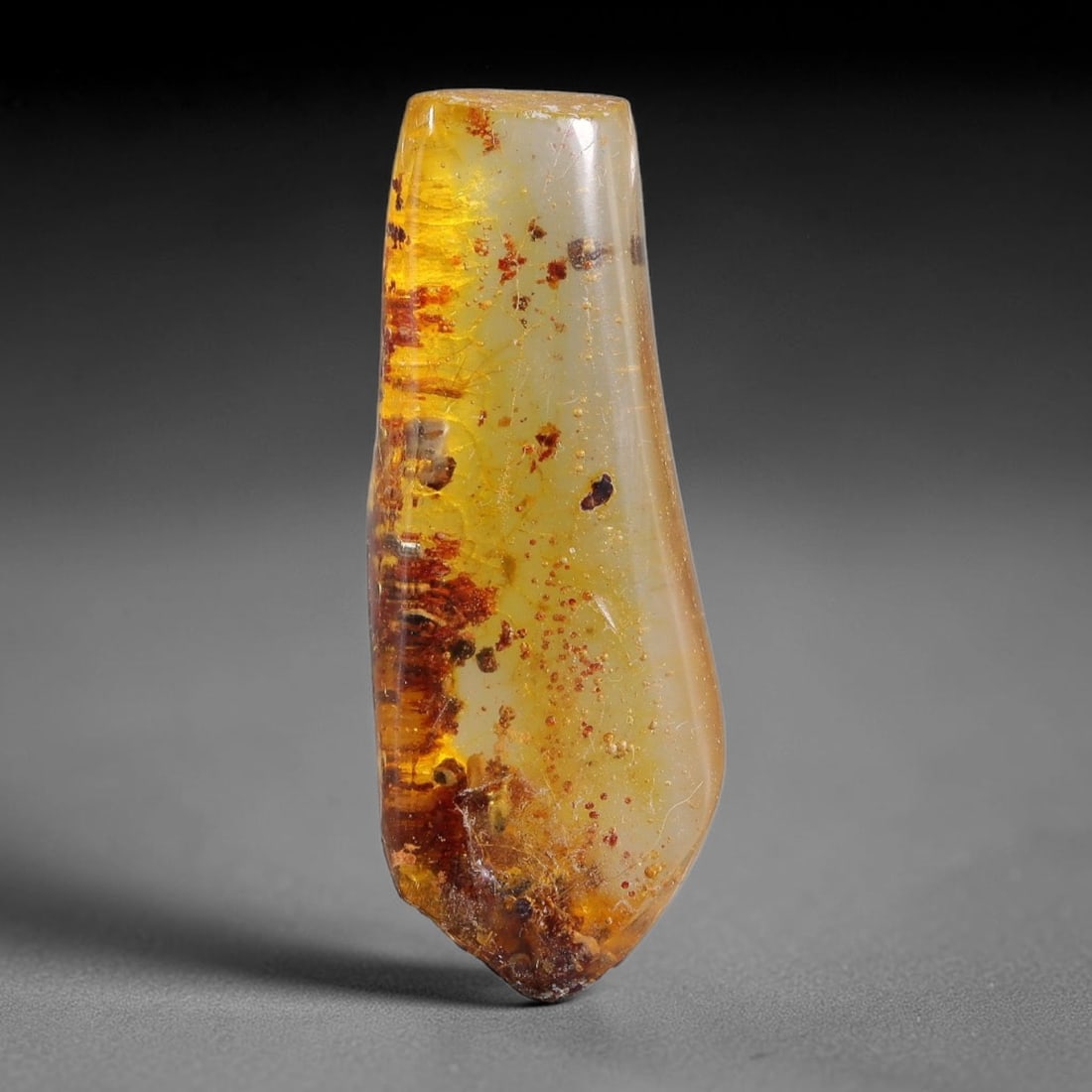 10.68ct Natural Baltic Polished Loose Freeform Amber Gemstone, 83FL: This smoothly polished freeform amber piece carries warm translucent organic clarity with fine natural fossil flecks and tiny mineral inclusions suspended throughout its 32x12x8mm flowing unstructured